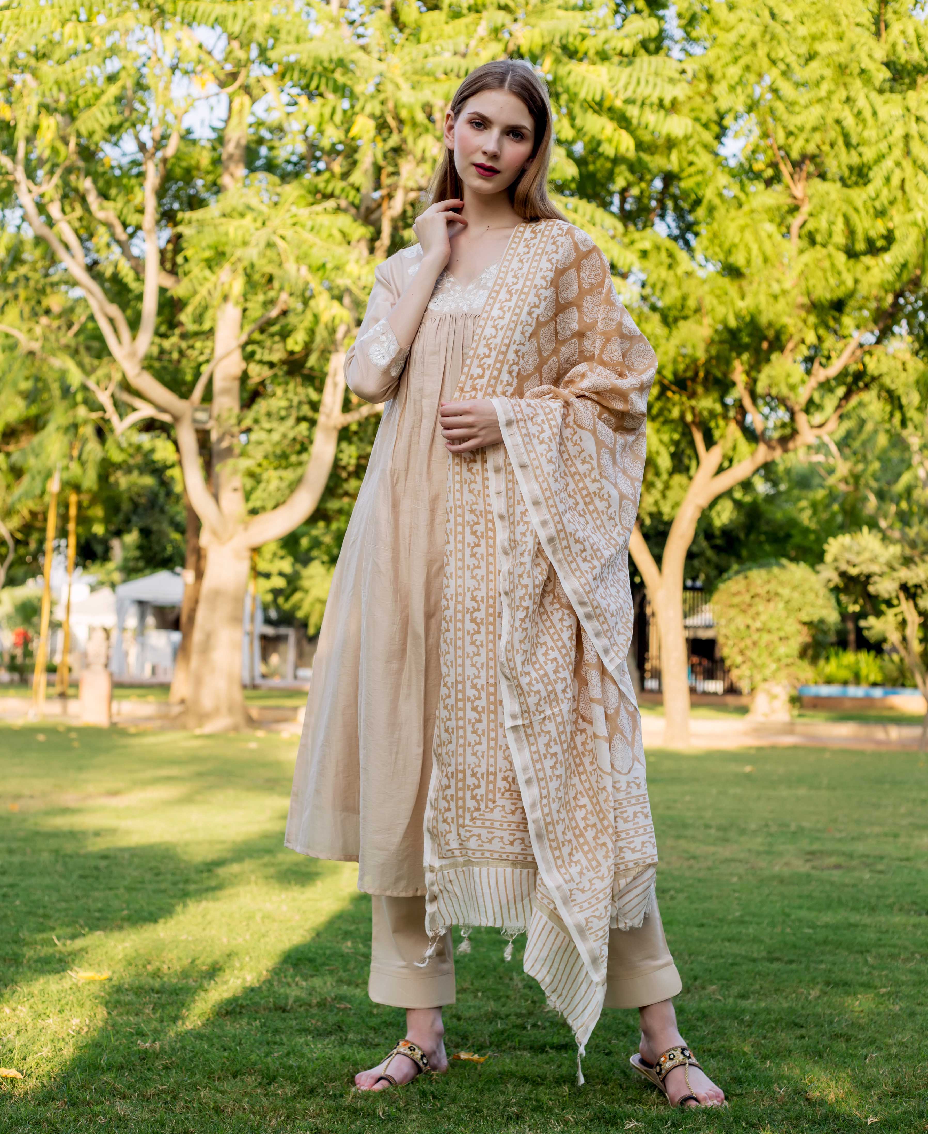 A model wearing a beige chanderi kurta with white embroidery and a matching dupatta.