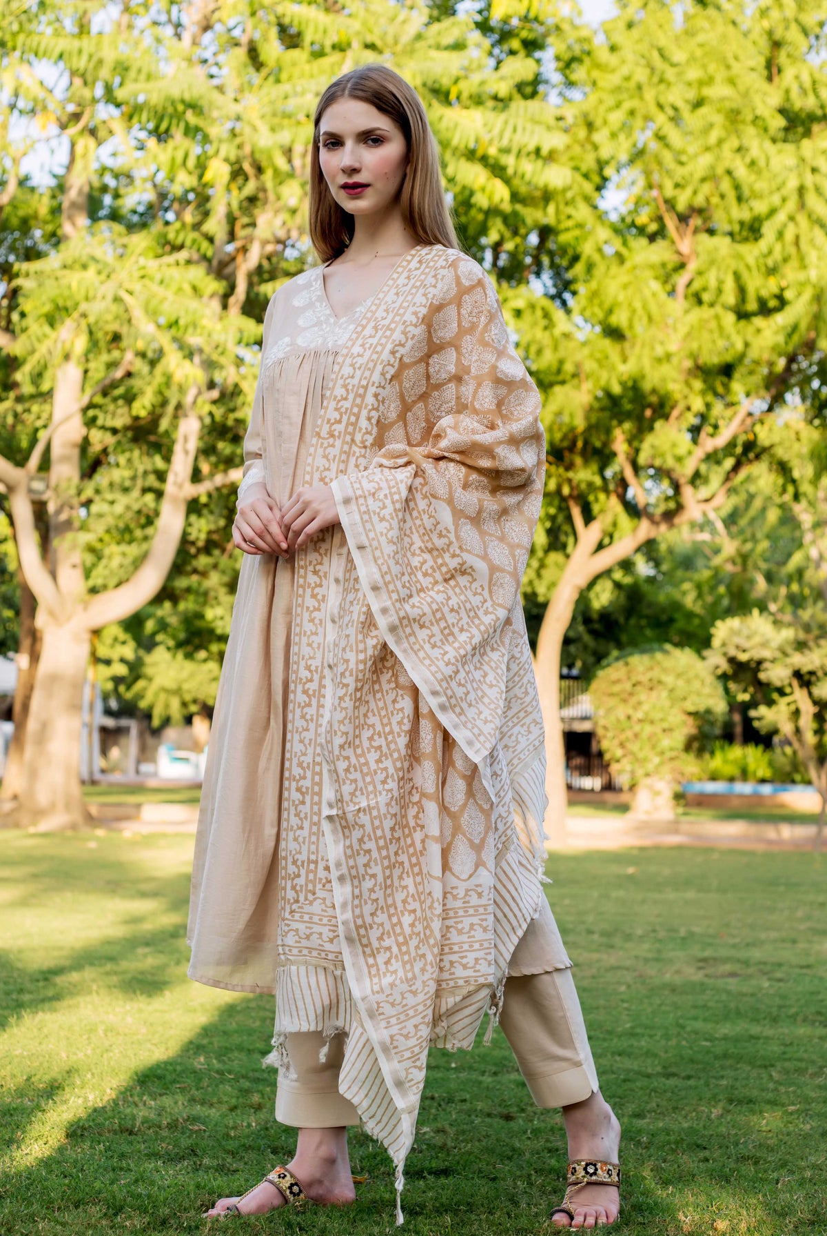 Model in beige embroidered kurta set with light brown block print dupatta, full-length front.