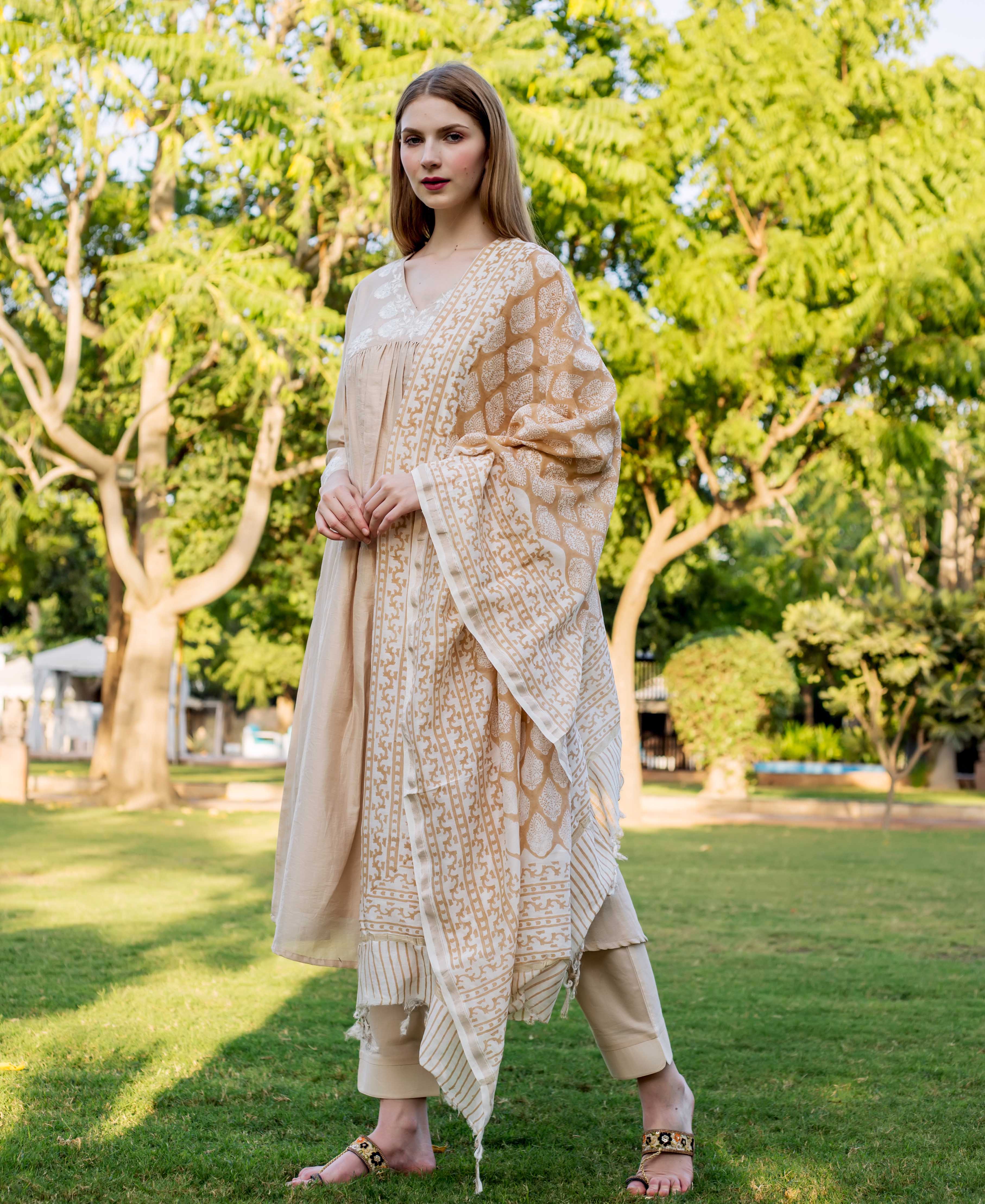 Model in beige embroidered kurta set with light brown block print dupatta, full-length front.