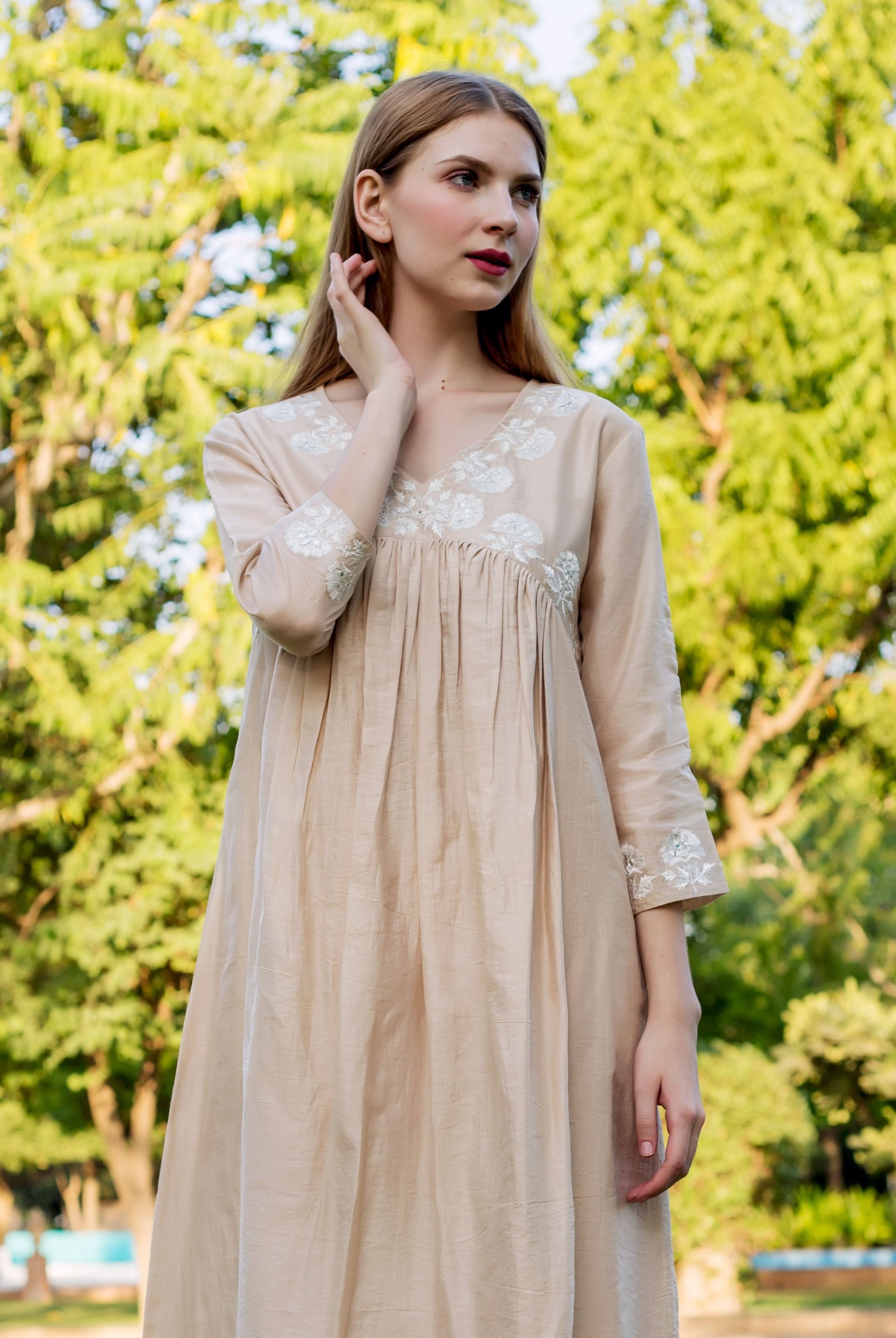Front view of model wearing a beige Chanderi kurta with white embroidered yoke and sleeves.