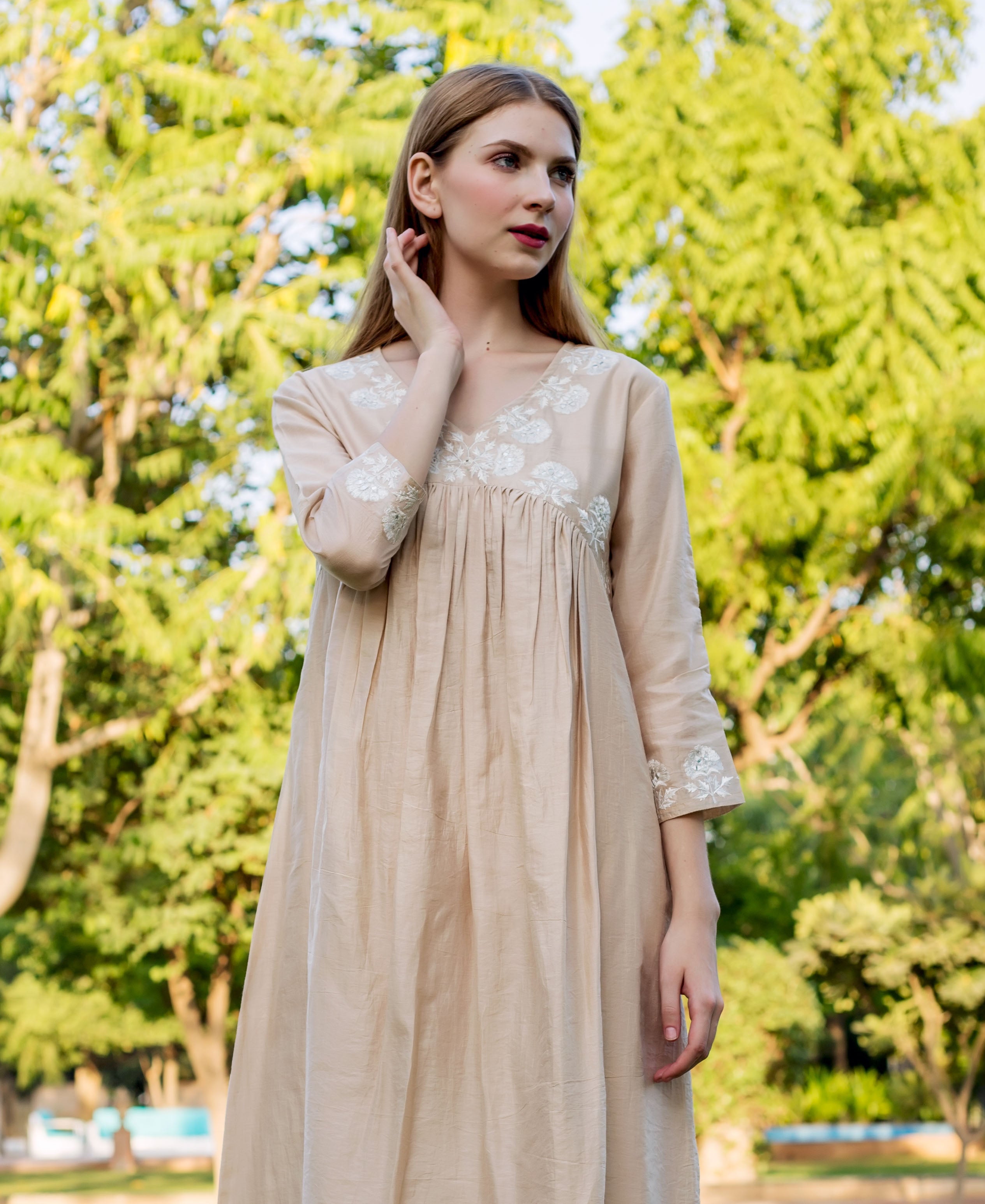 Front view of model wearing a beige Chanderi kurta with white embroidered yoke and sleeves.
