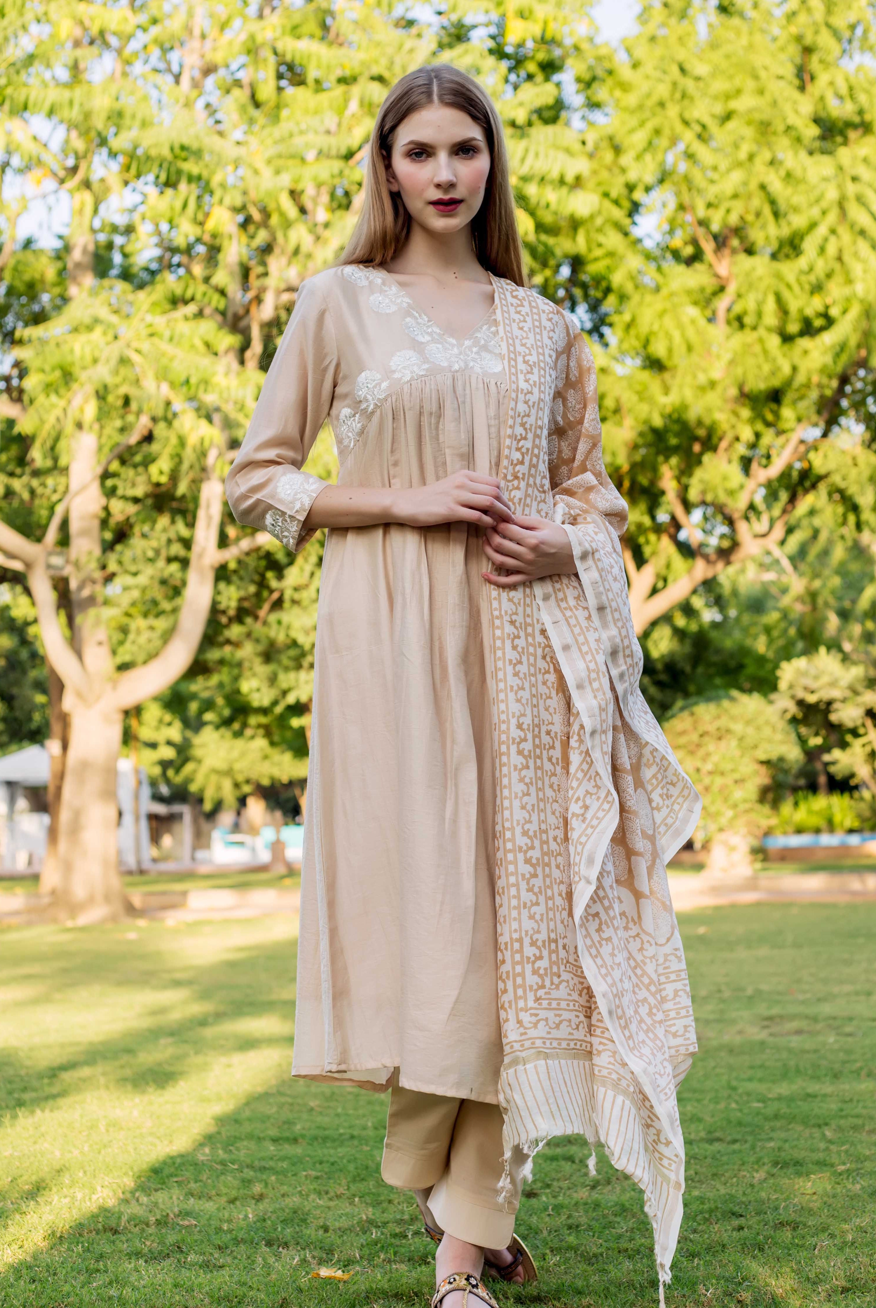 Beige embroidered kurta on model with white floral details and matching patterned dupatta.