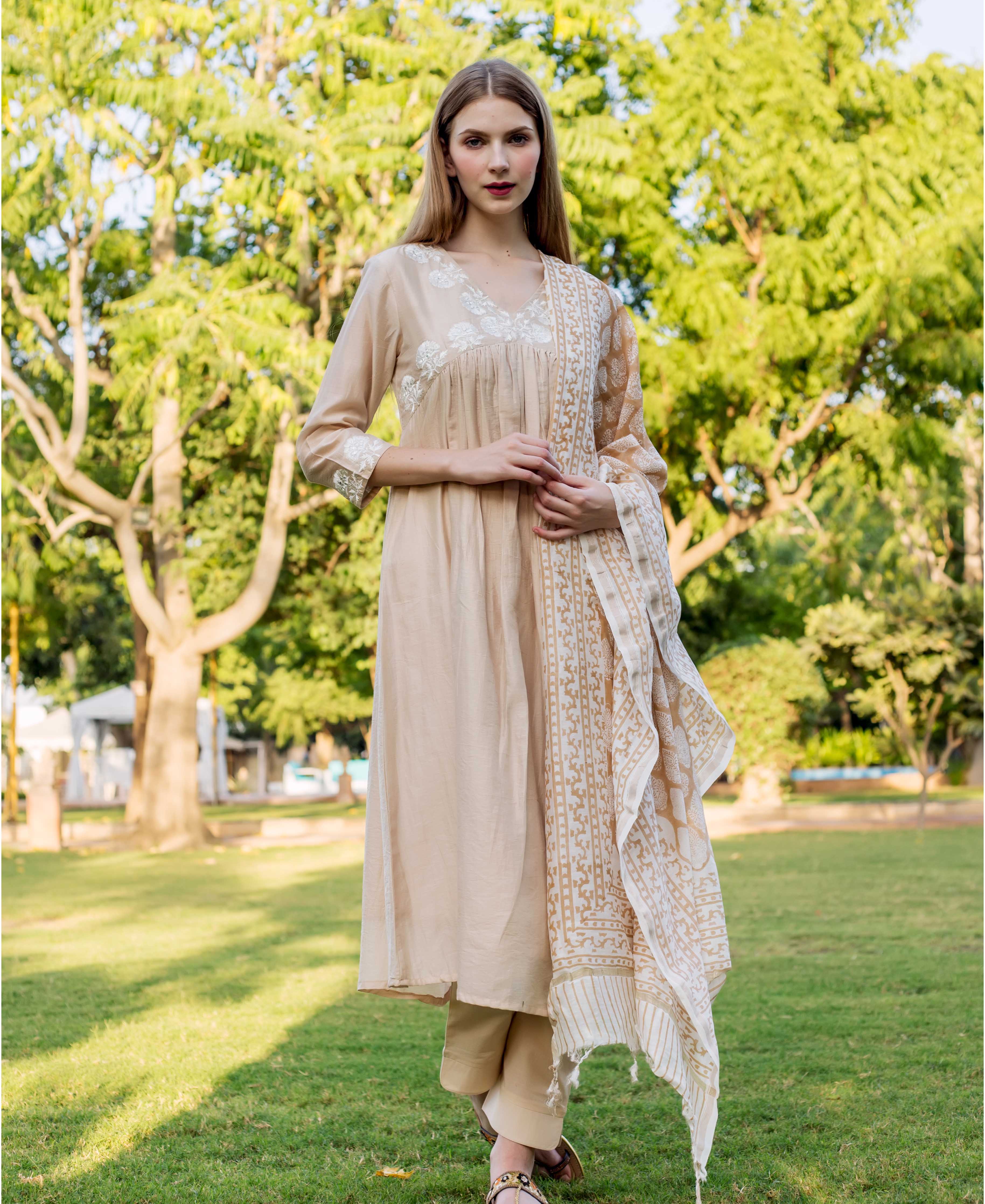 Beige embroidered kurta on model with white floral details and matching patterned dupatta.