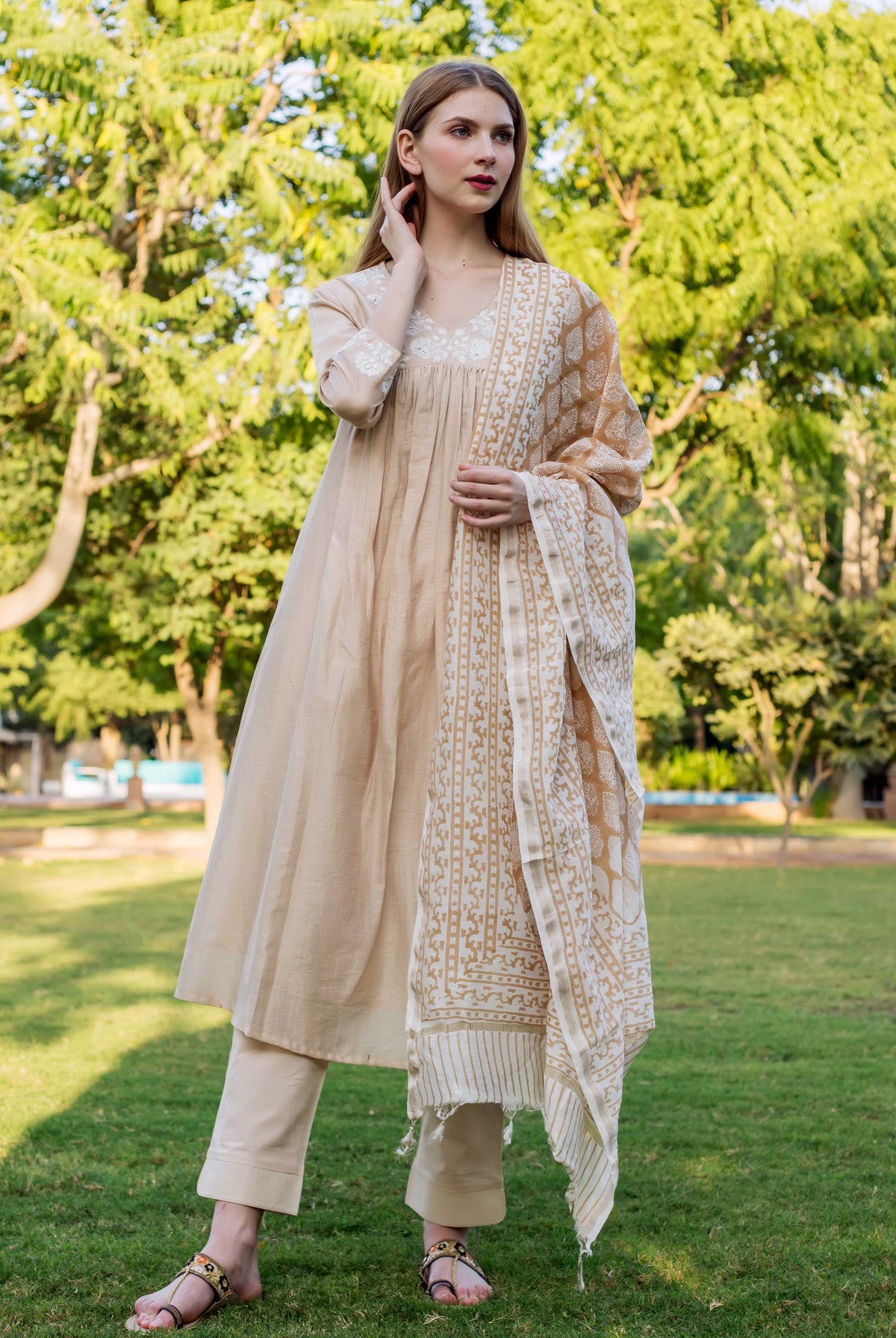 Beige chanderi embroidered kurta with white and gold print, on a female model outdoors.