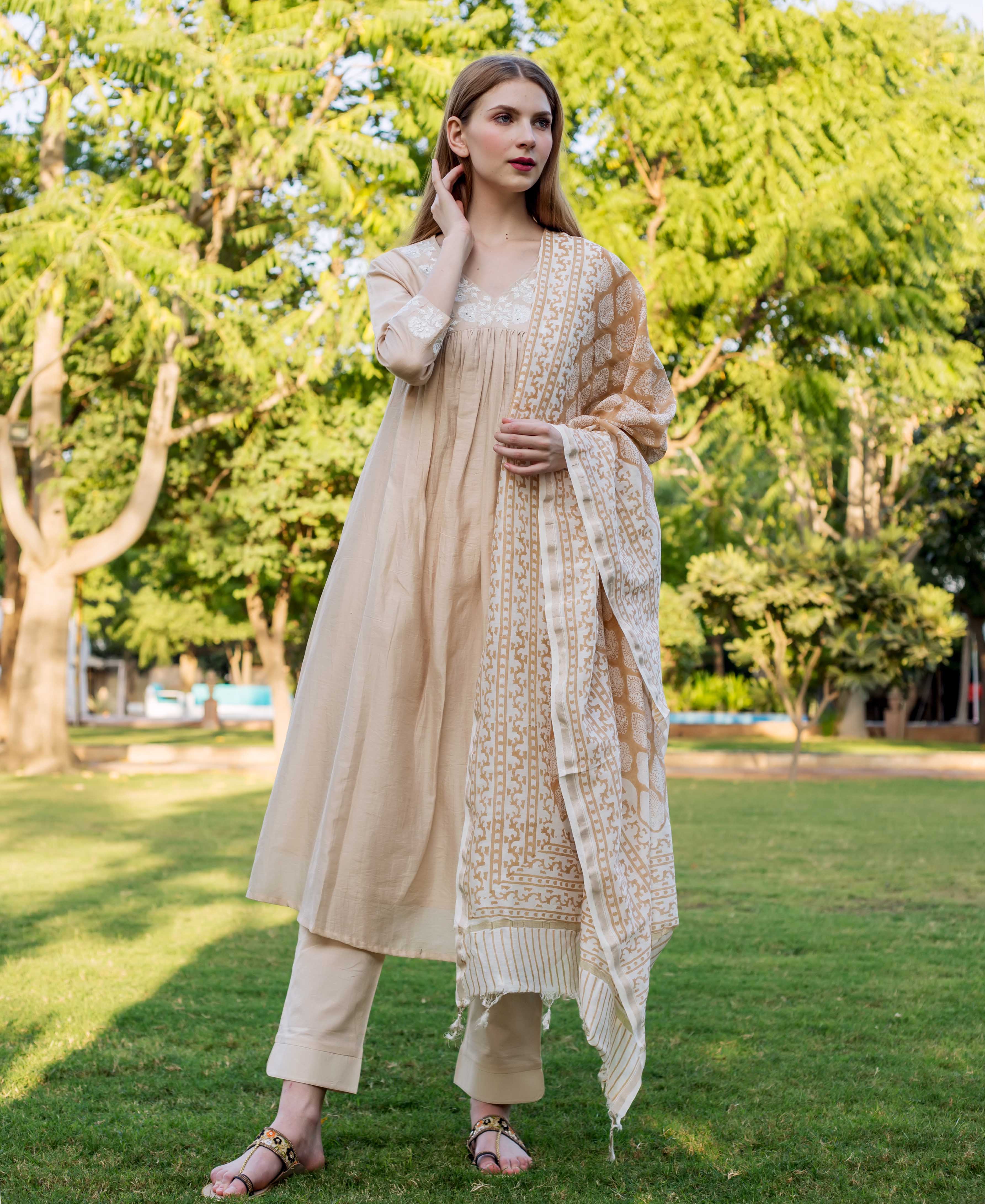 Beige chanderi embroidered kurta with white and gold print, on a female model outdoors.
