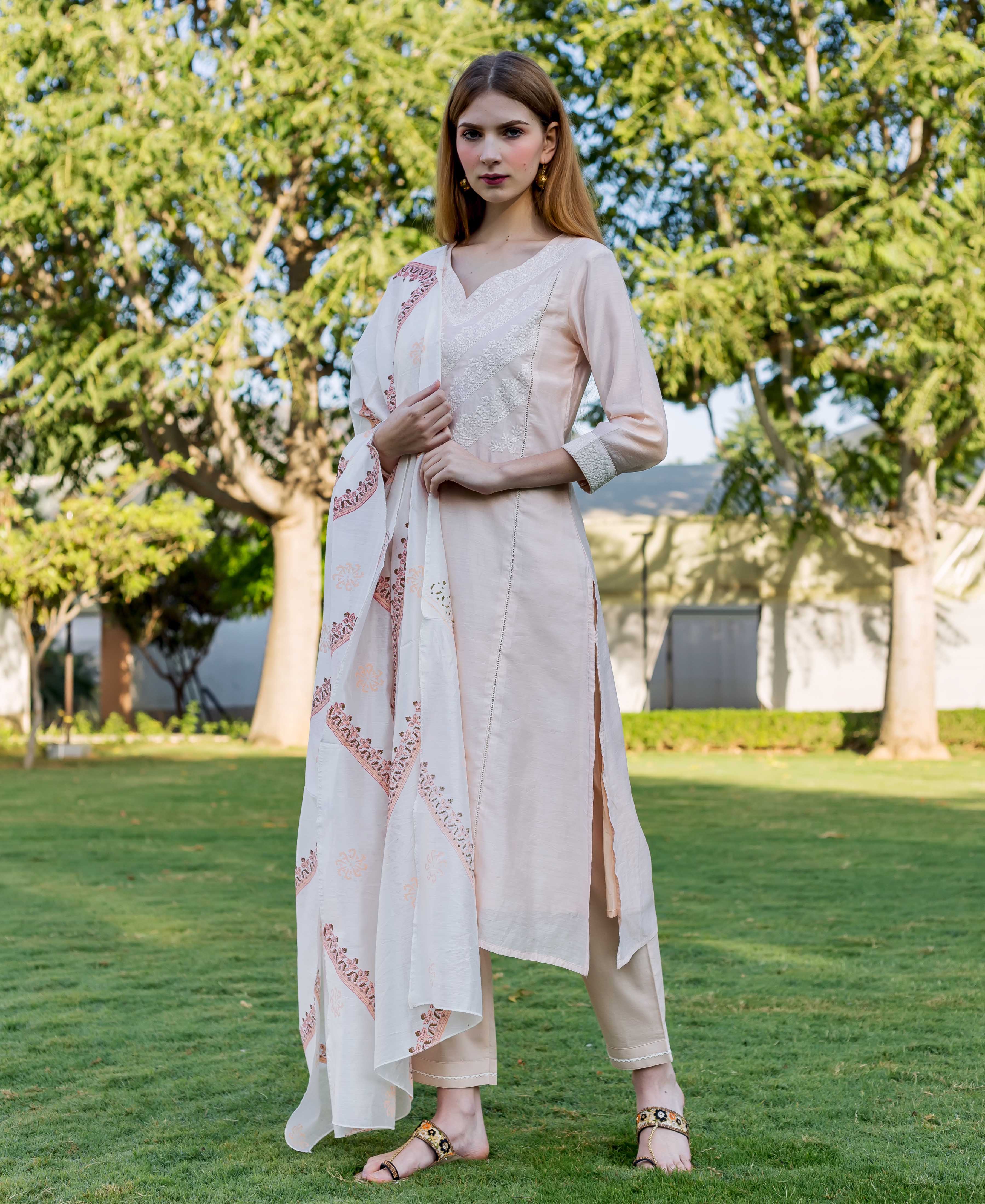 Full-length model wearing a Zahreen baby pink embroidered kurta with a white hand-block-printed dupatta.