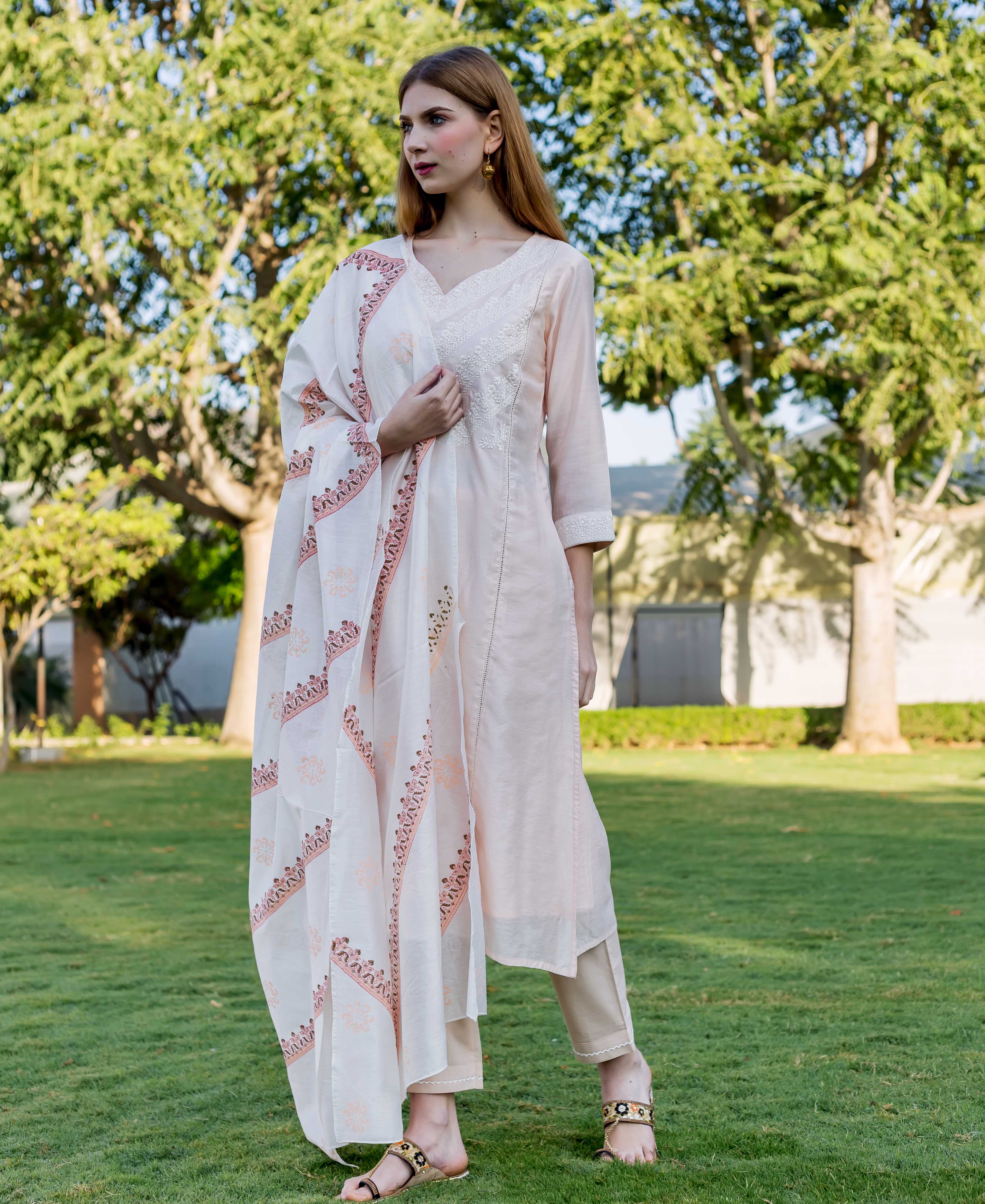 Female model wearing baby pink embroidered kurta, white block-printed dupatta, and beige pants.