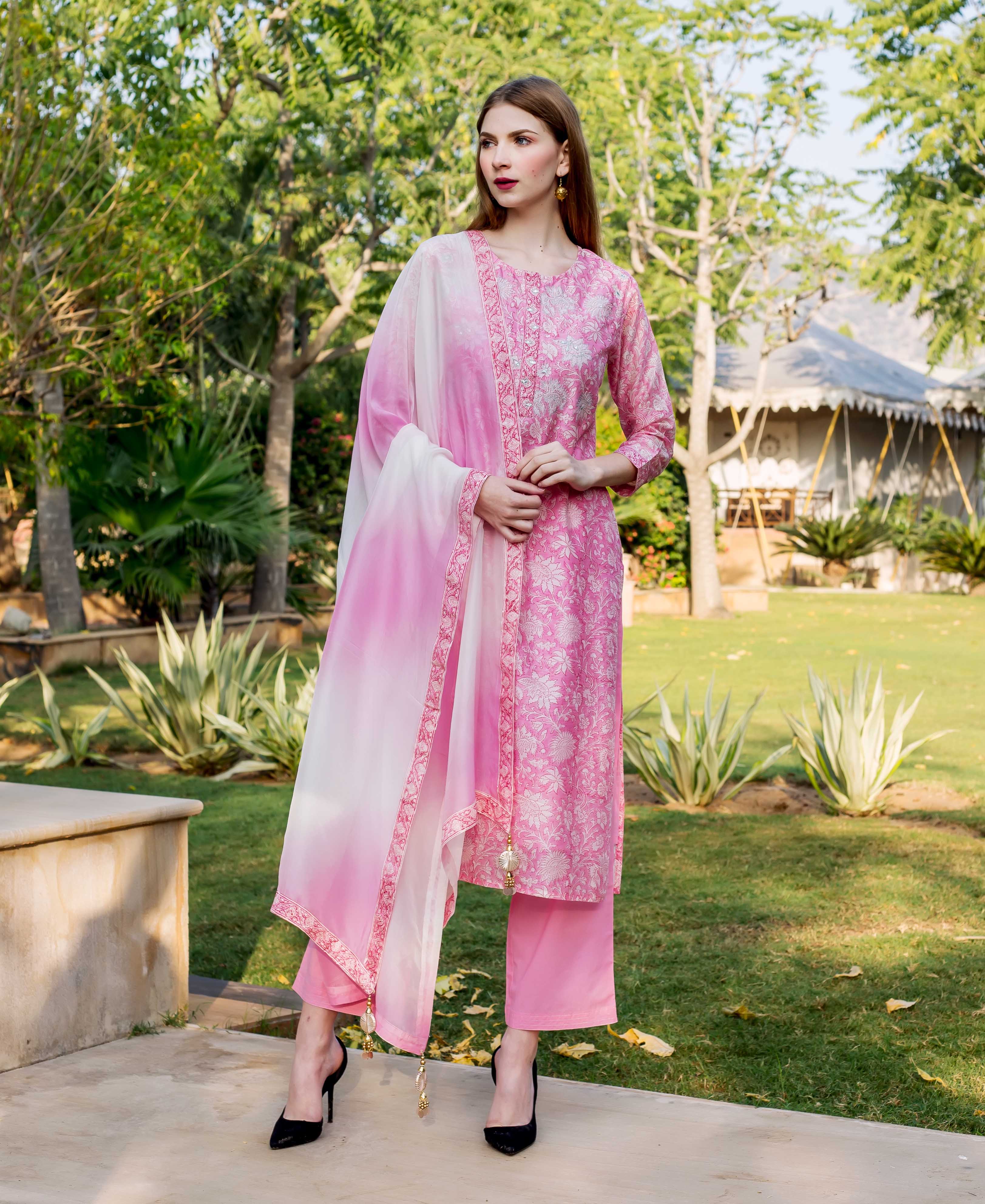 Pink hand block printed and embroidered kurta set on female model, standing outdoors.