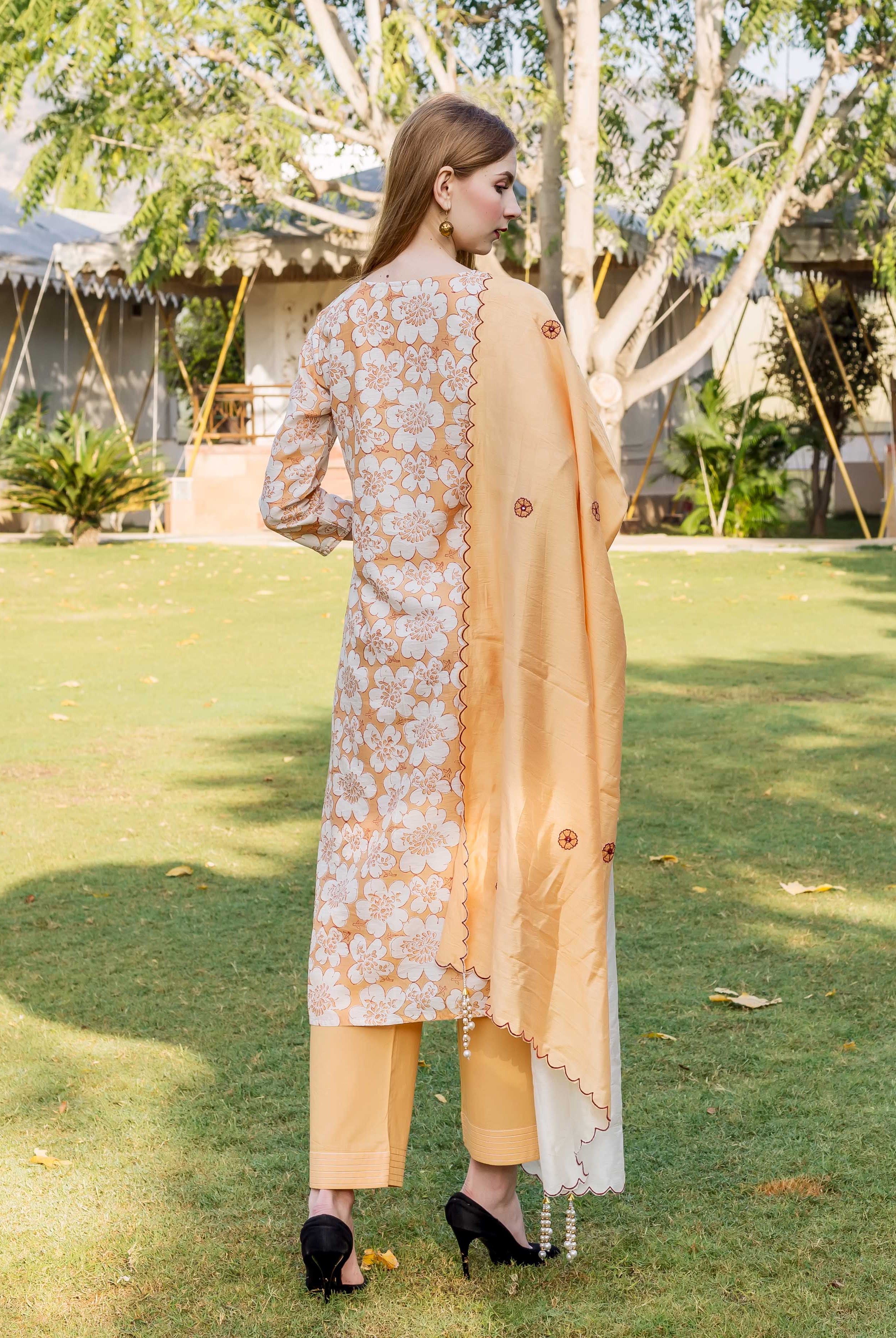 Rear view of model wearing a golden yellow floral block printed chanderi kurta set.