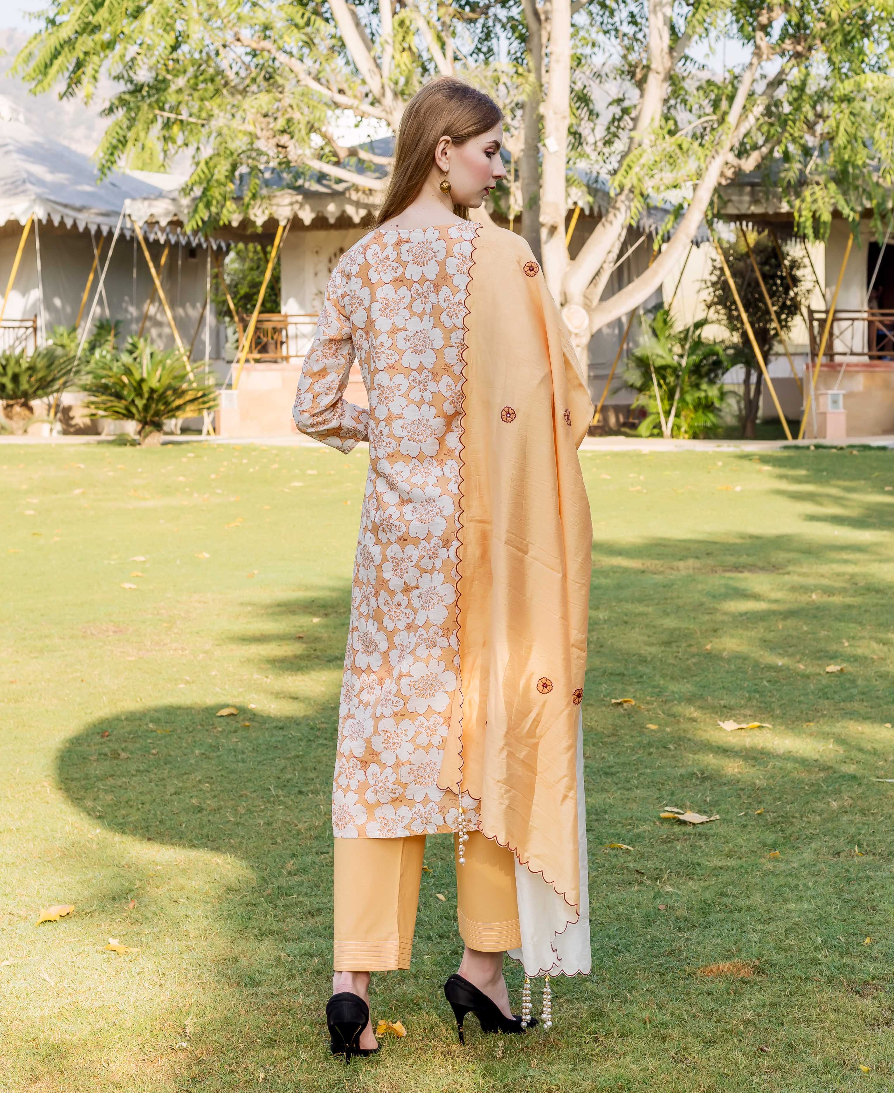 Rear view of model wearing a golden yellow floral block printed chanderi kurta set.
