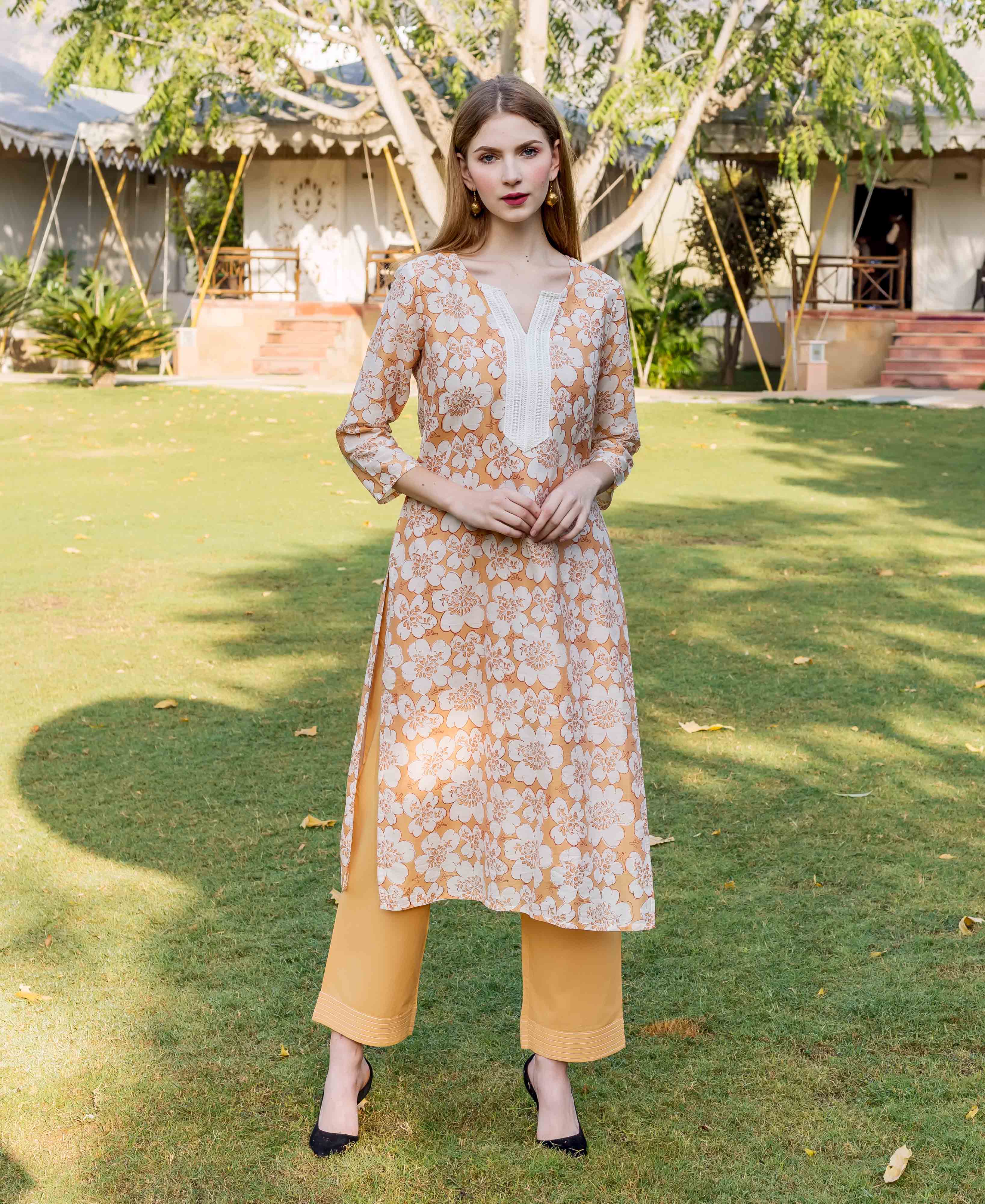 Front full look of a model in a golden yellow block printed floral kurta.
