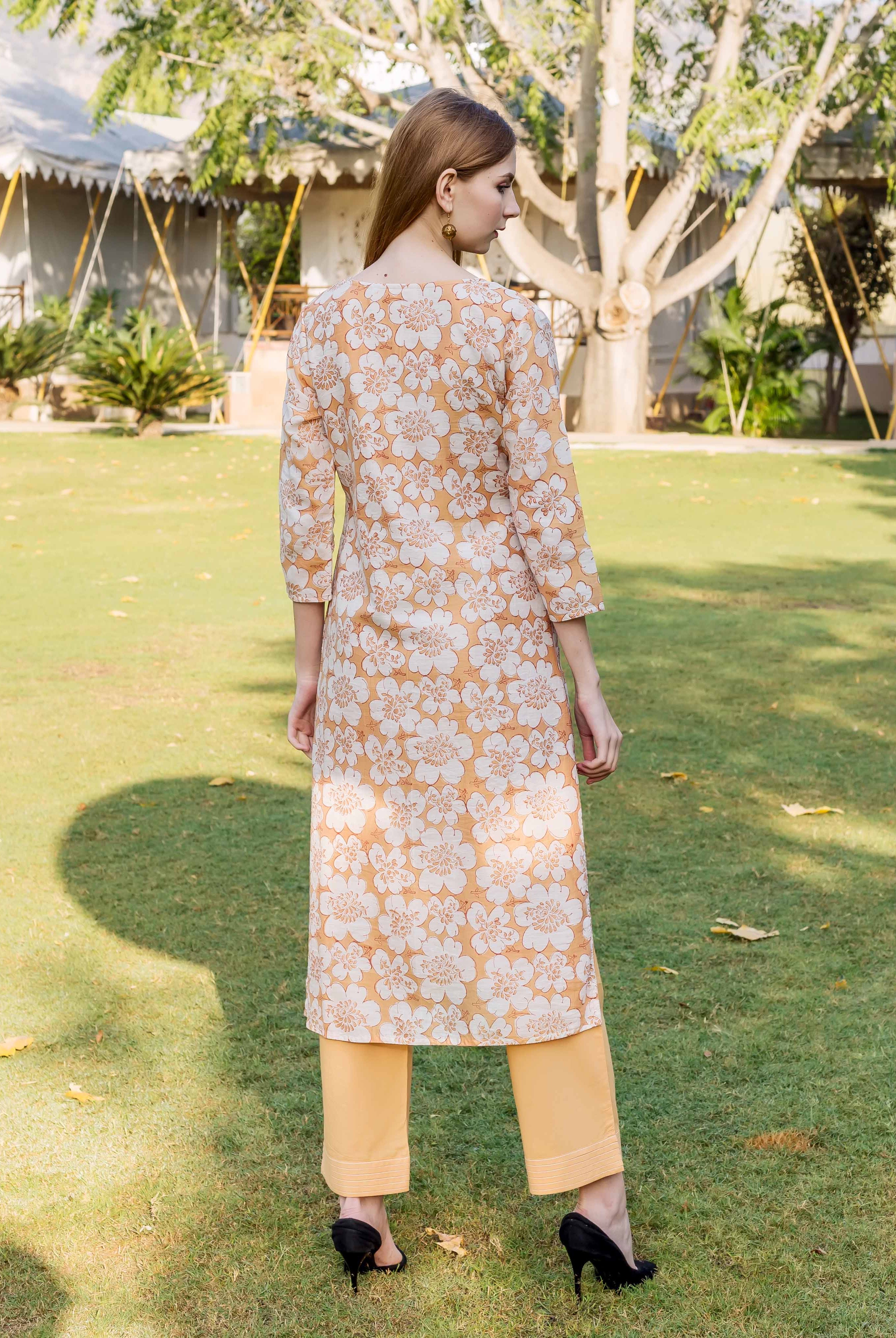 Rear view of a model in a golden yellow floral block printed Chanderi kurta.