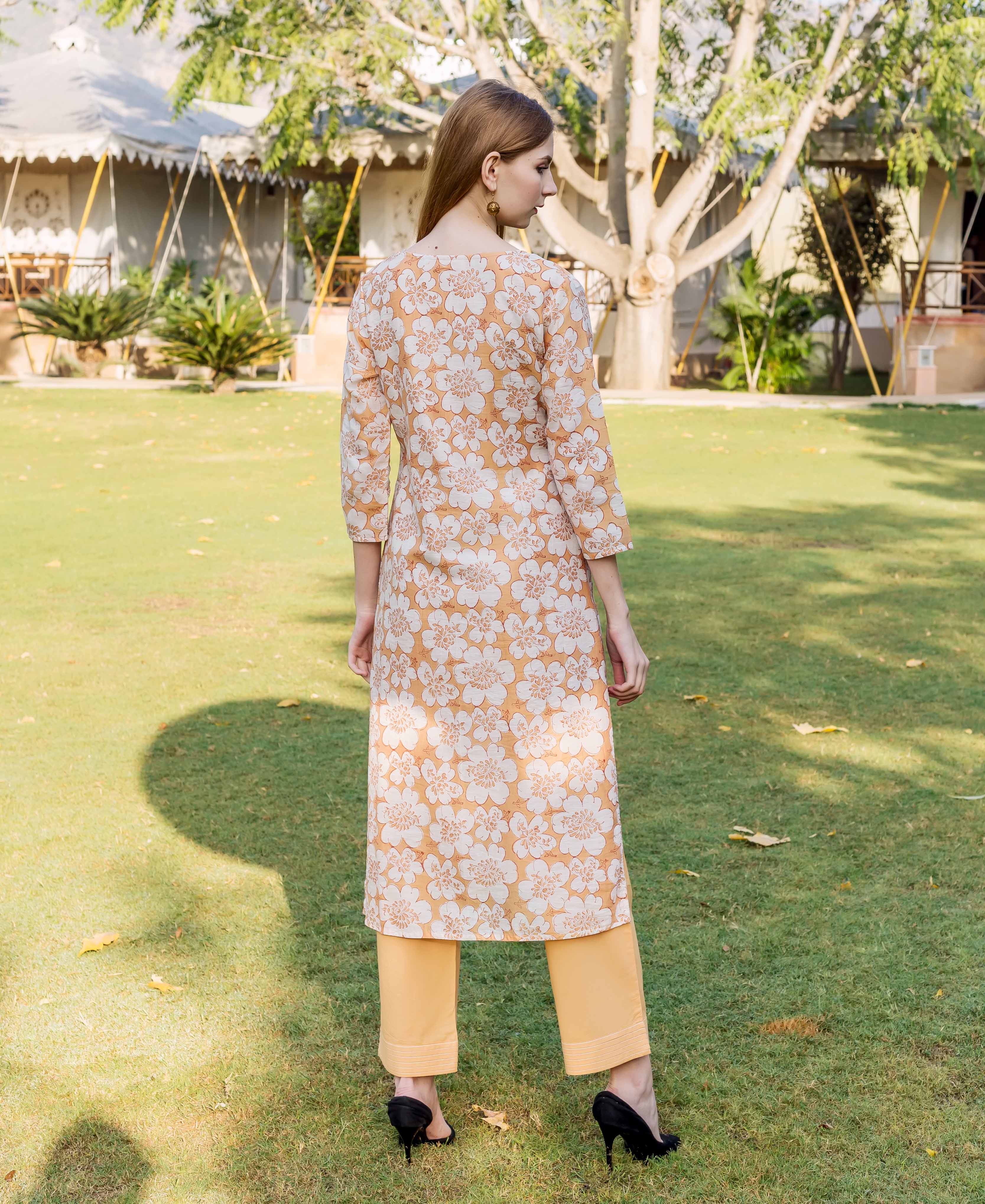 Rear view of a model in a golden yellow floral block printed Chanderi kurta.