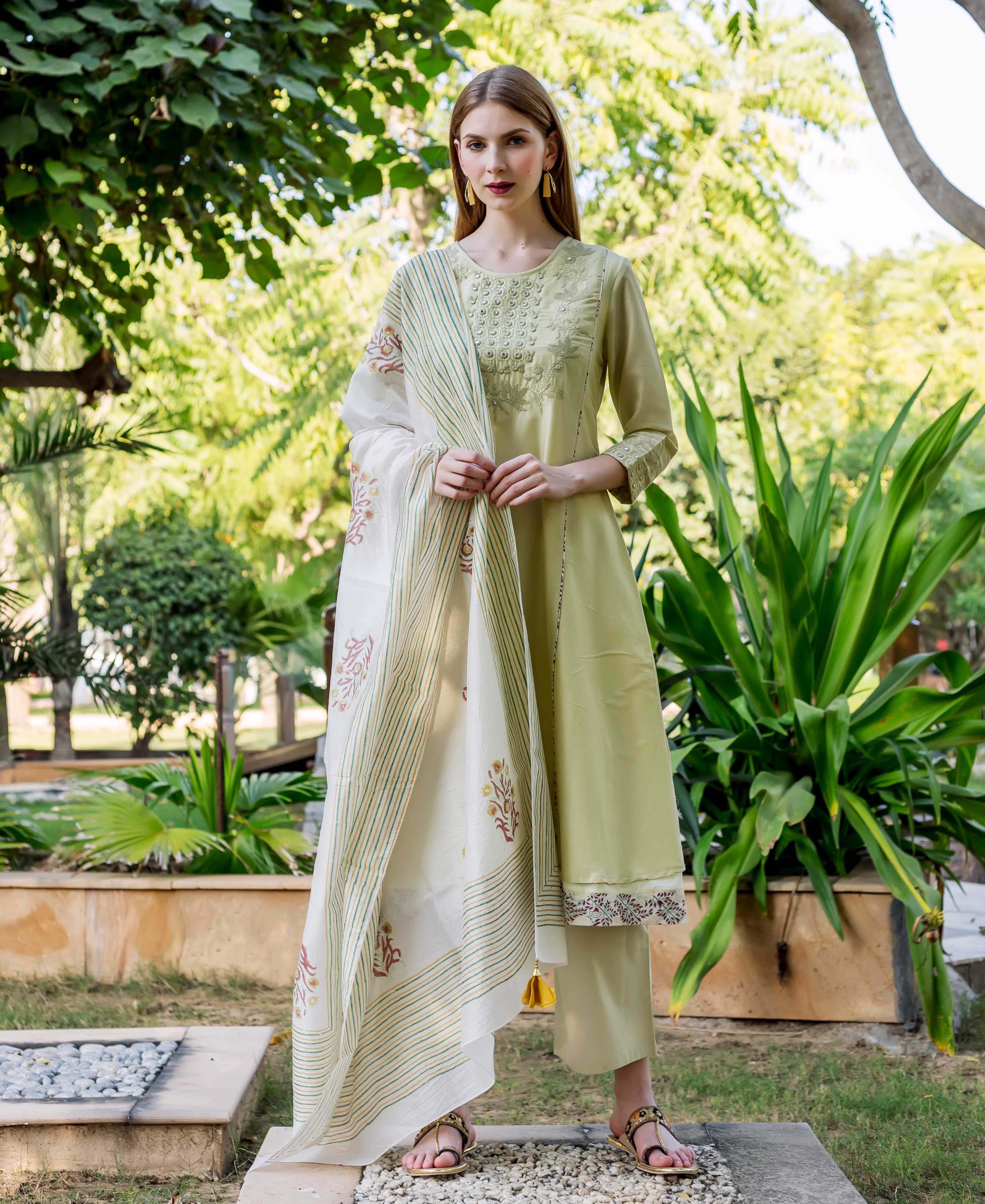 Model in a sea green embroidered A-line kurta, printed hem, and floral block-print dupatta.