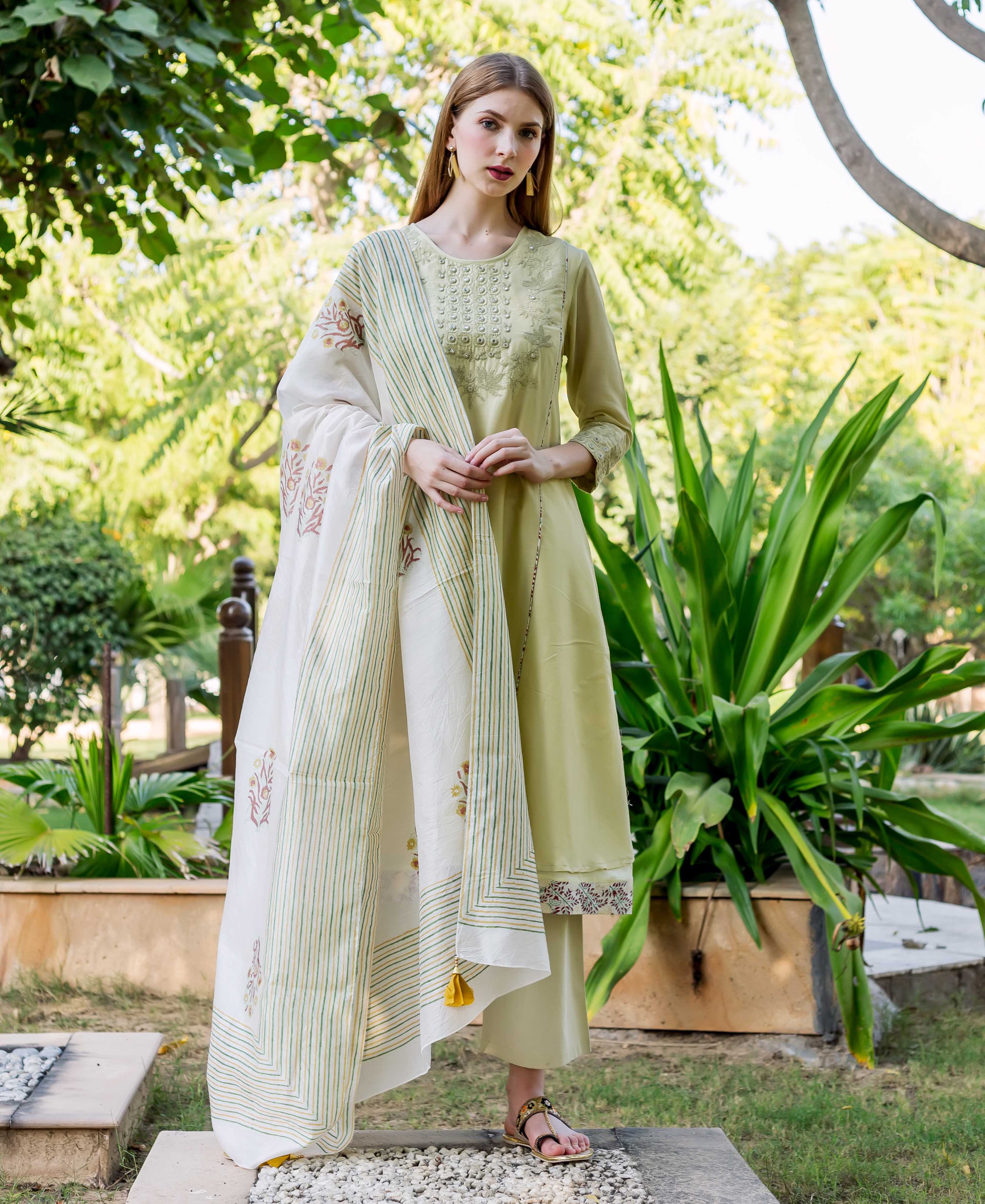 Model in sea green embroidered A-line kurta, printed hem, and white block-printed dupatta.