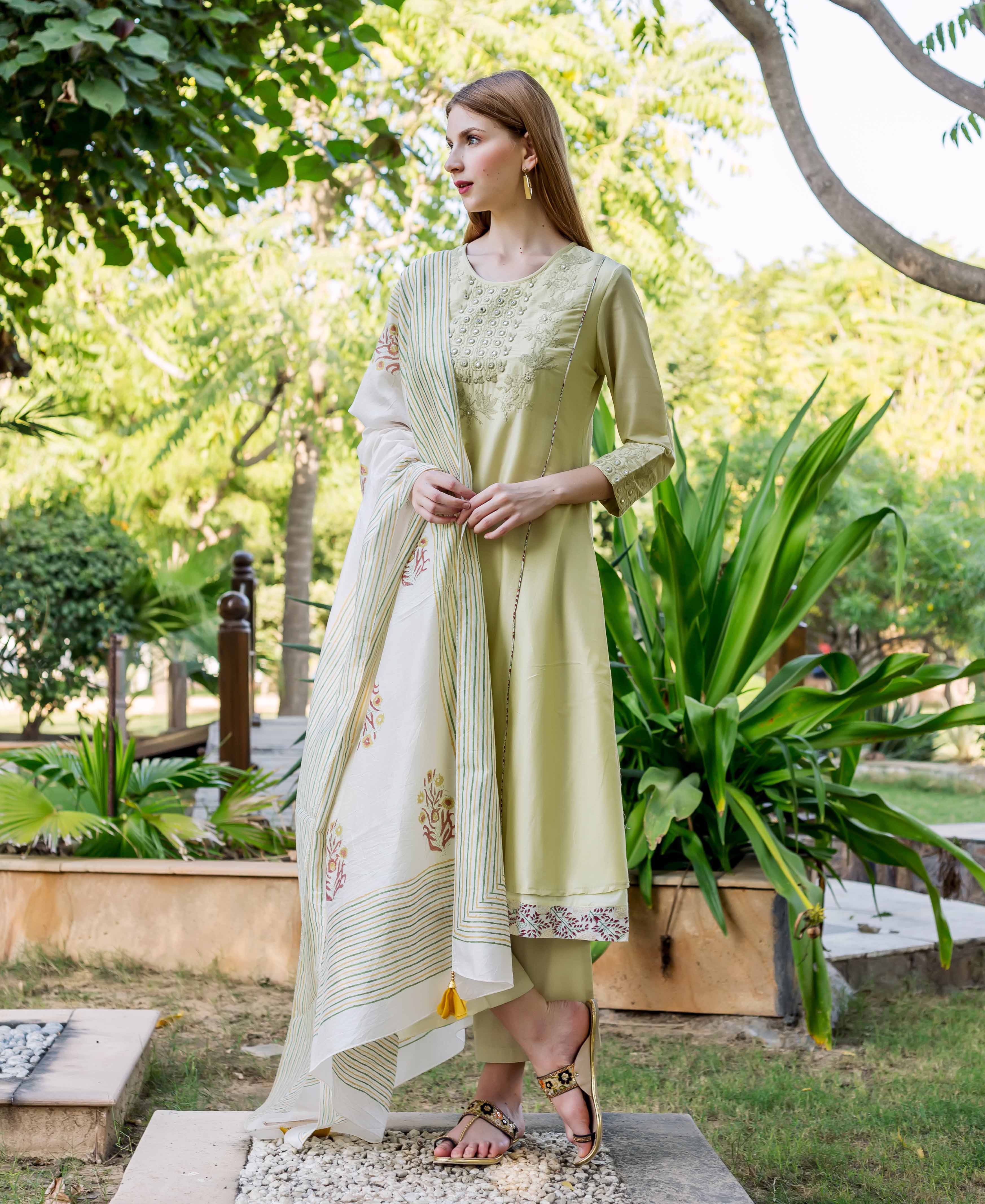 Sea green embroidered A-line kurta with printed hem and white block-printed dupatta on model.