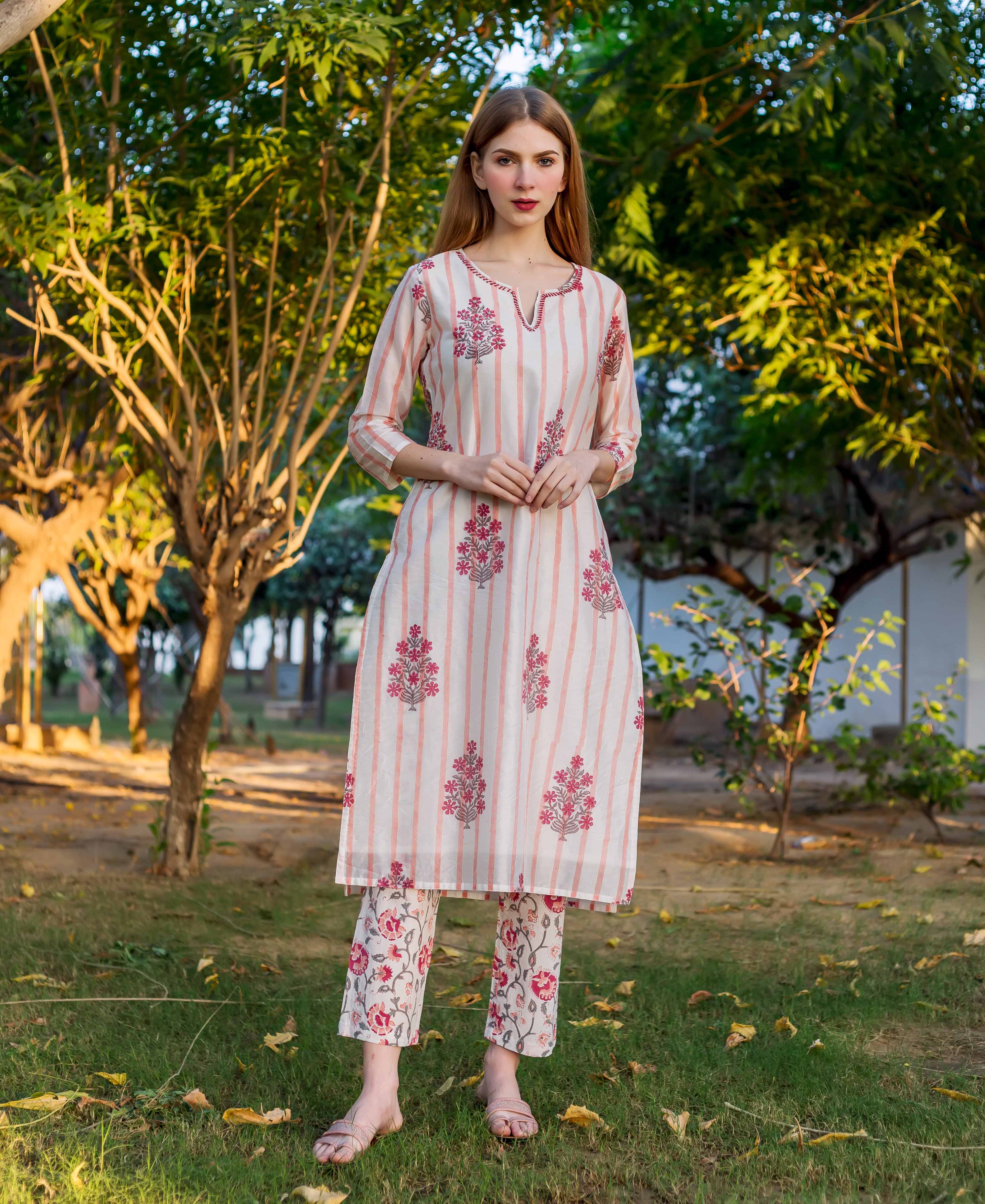 A model wearing a white and pink striped kurta with floral prints.