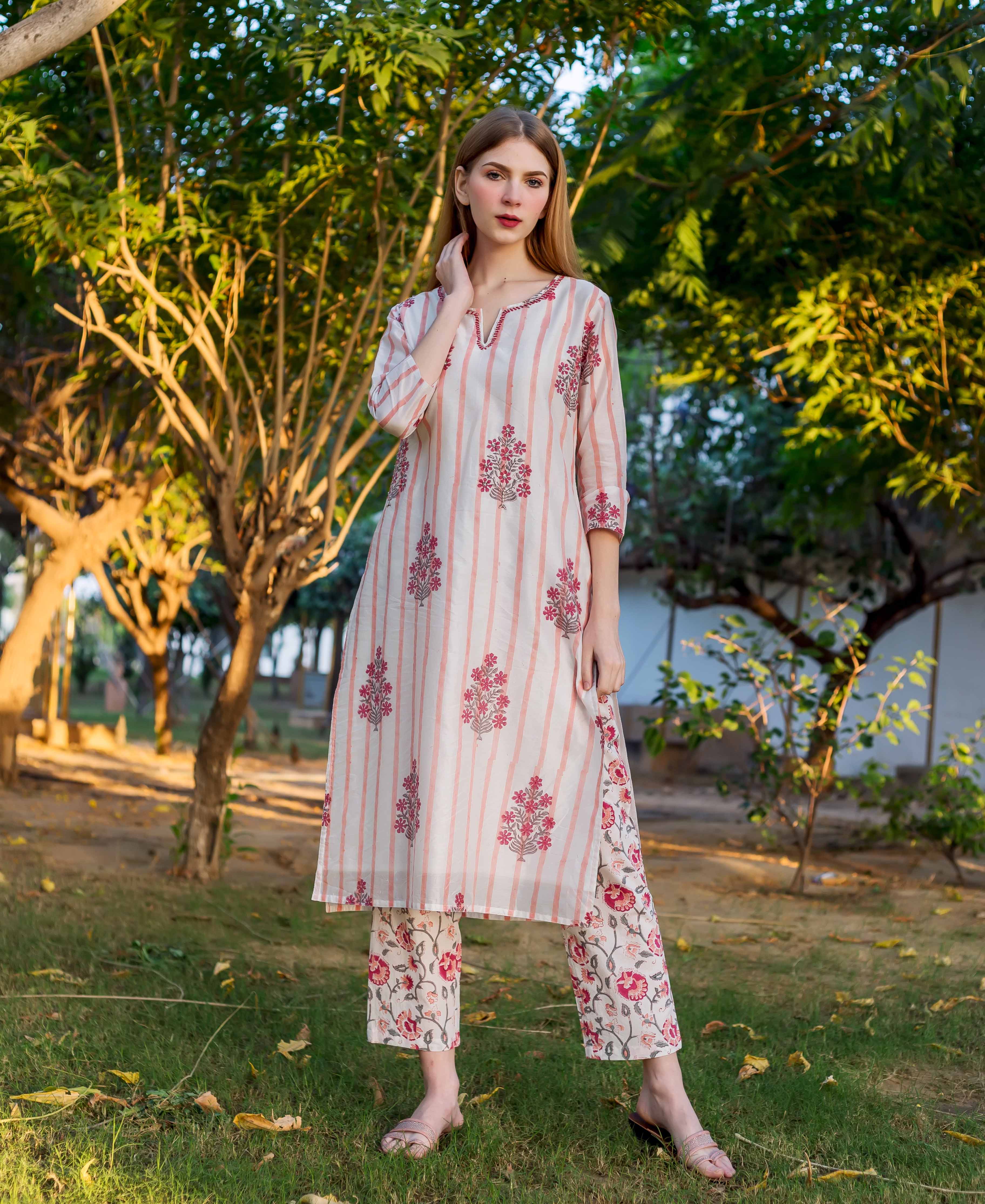 A model wearing a white and pink striped kurta with floral print.