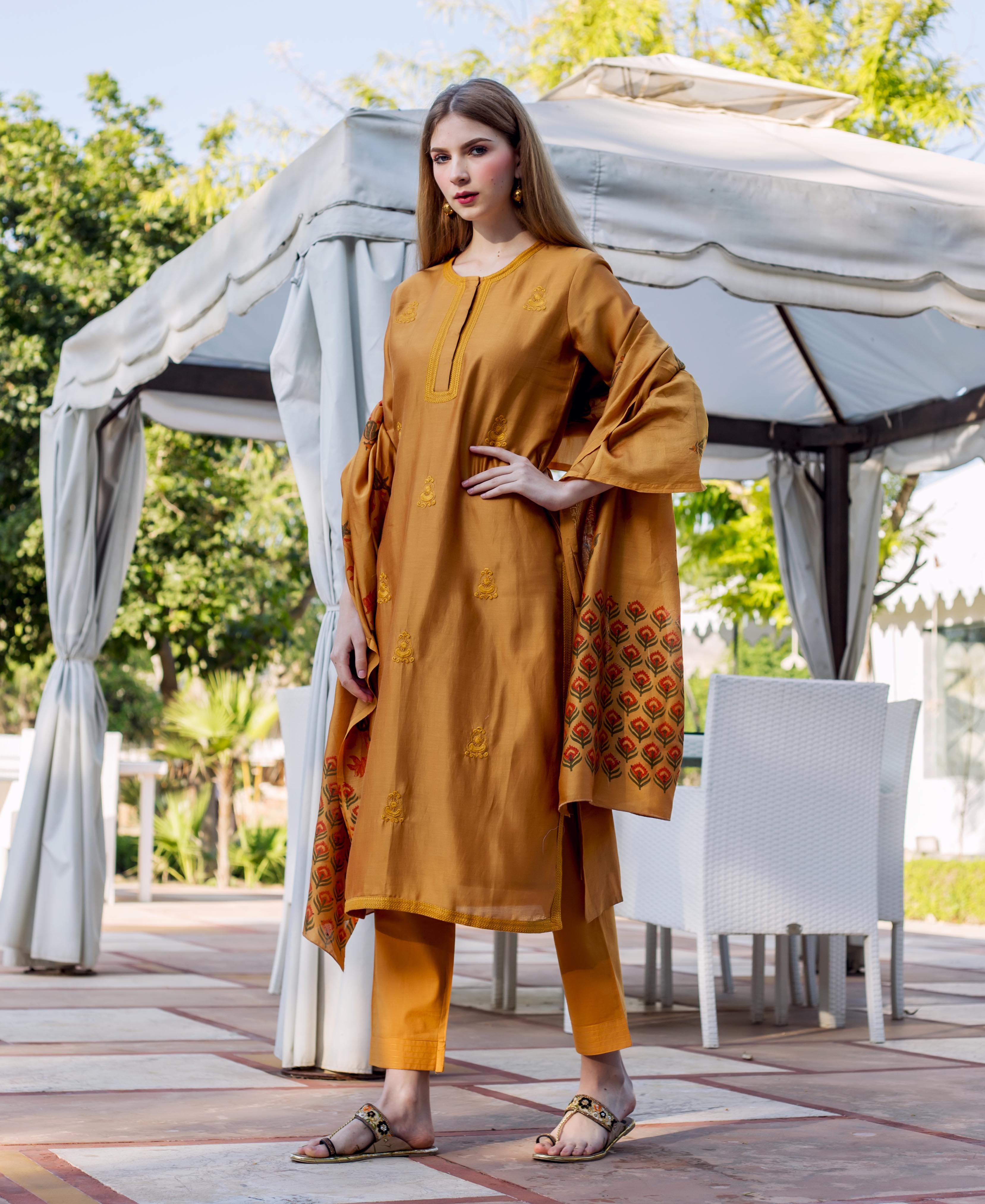 Full-length model in golden mustard embroidered kurta set with block-printed dupatta.