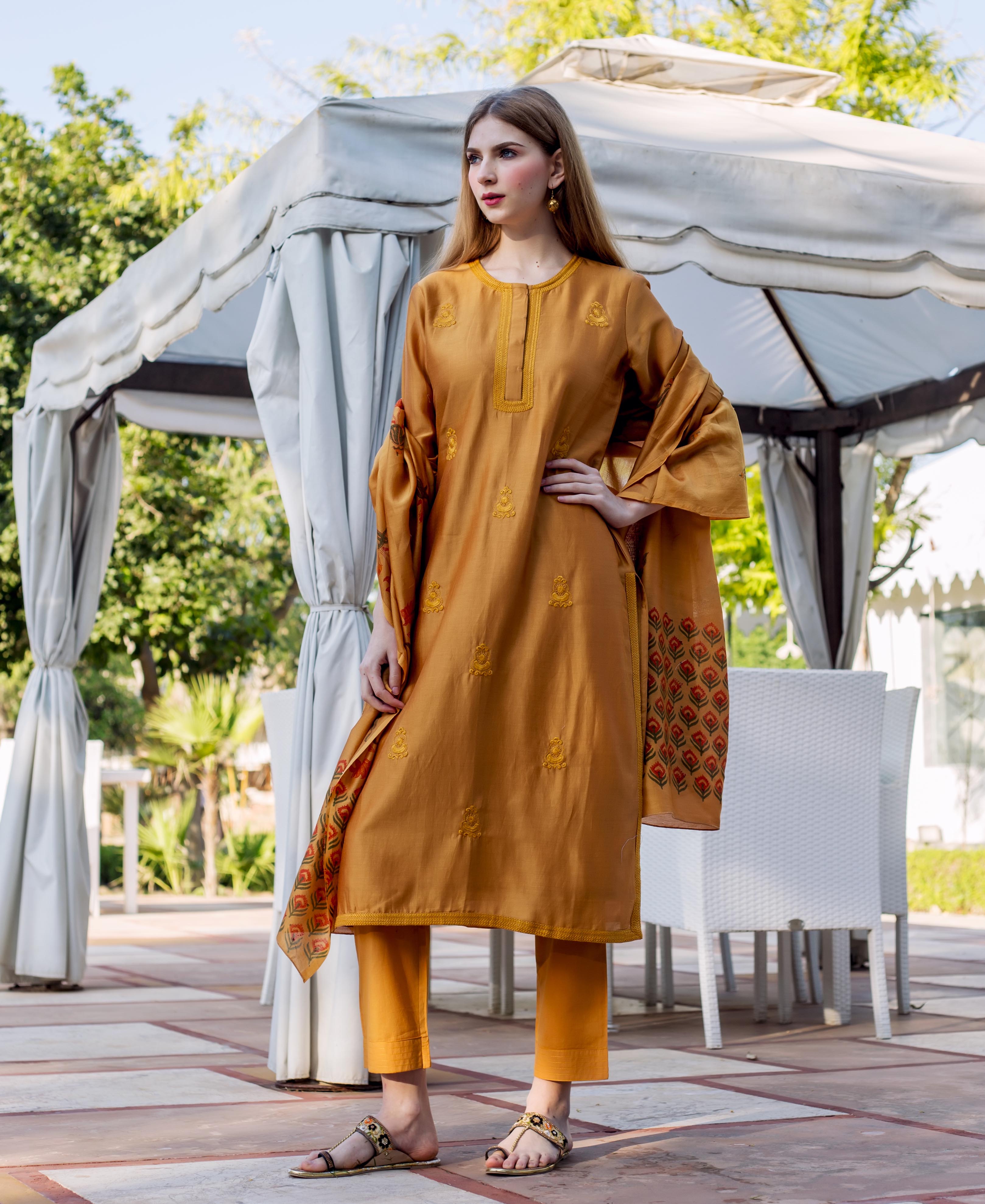 Model wears a golden yellow embroidered kurta, matching pants, and a patterned dupatta.