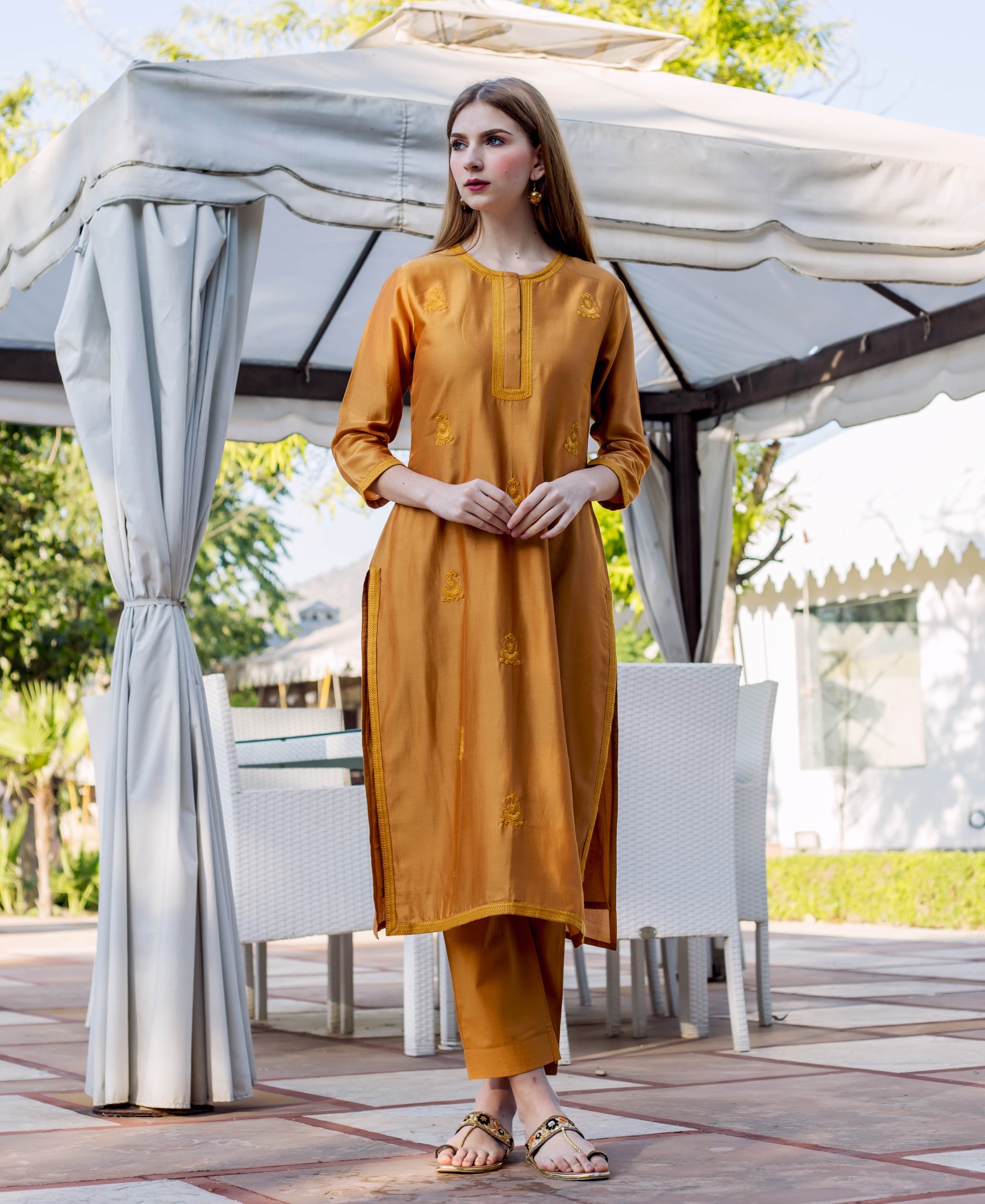 Full front view of model wearing an autumn rust embroidered kurta and matching trousers.