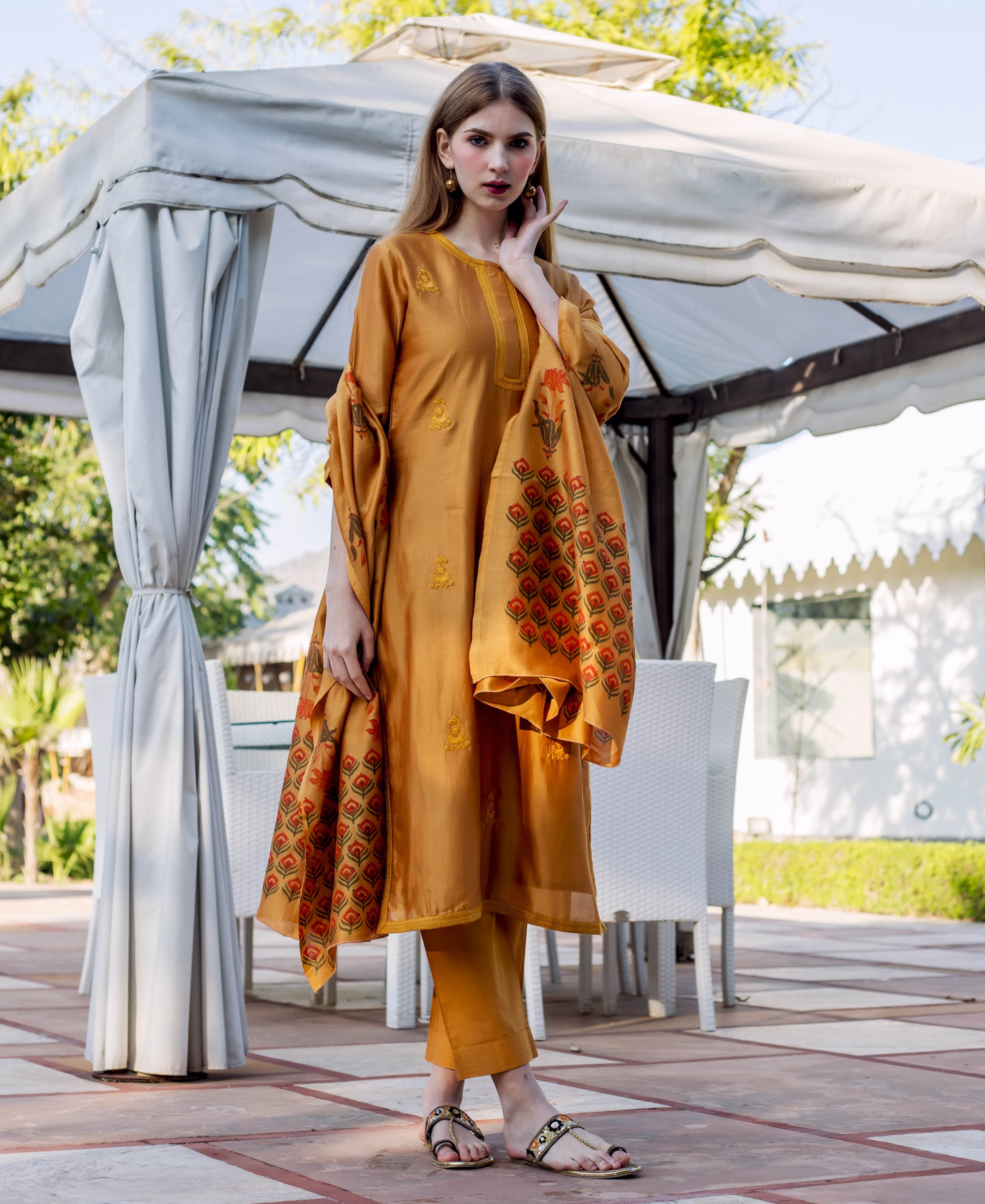 Front view of model in autumn rust embroidered kurta and hand-block printed dupatta.