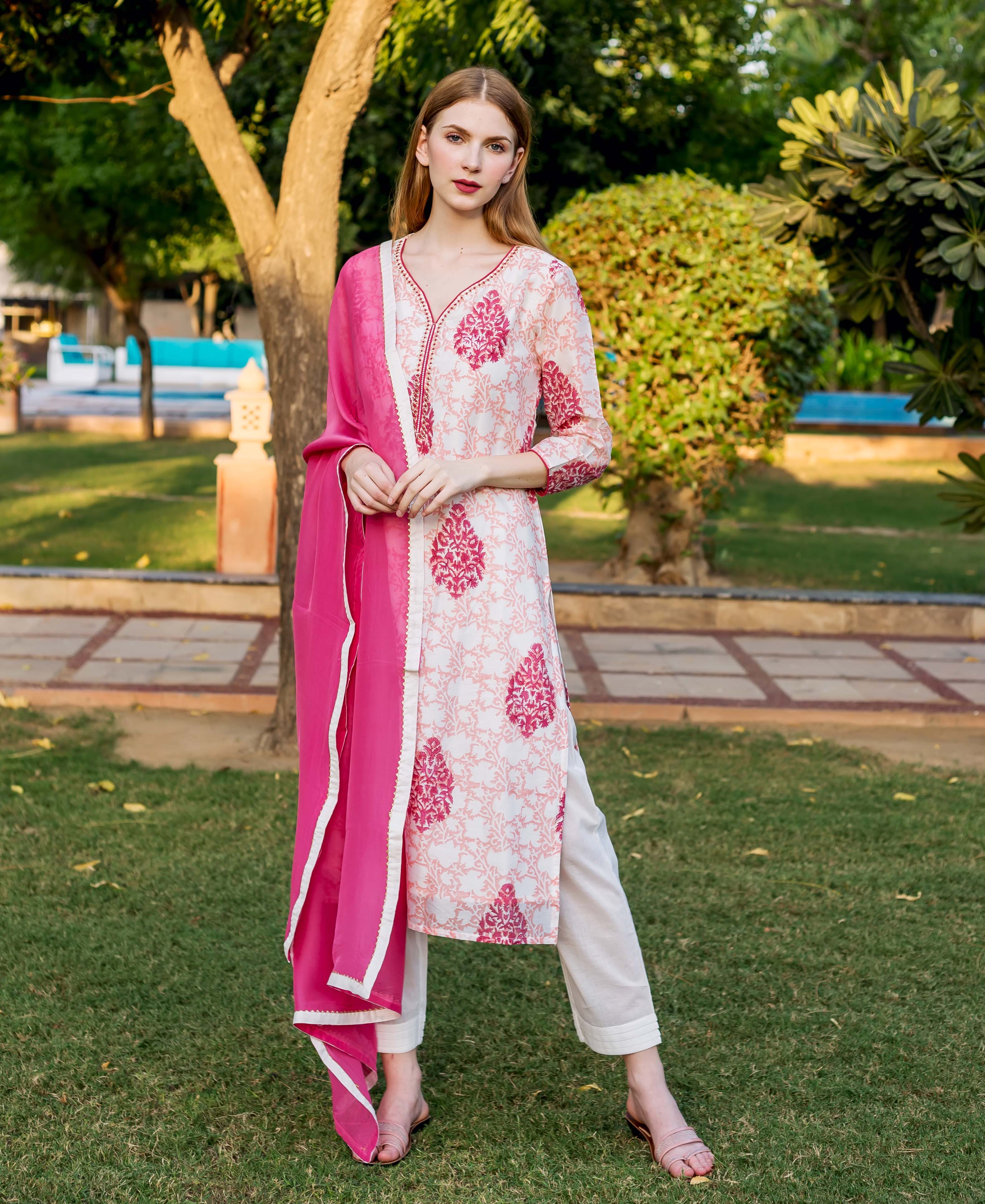 Full-length model wears a white, peach, and pink block printed kurta set.