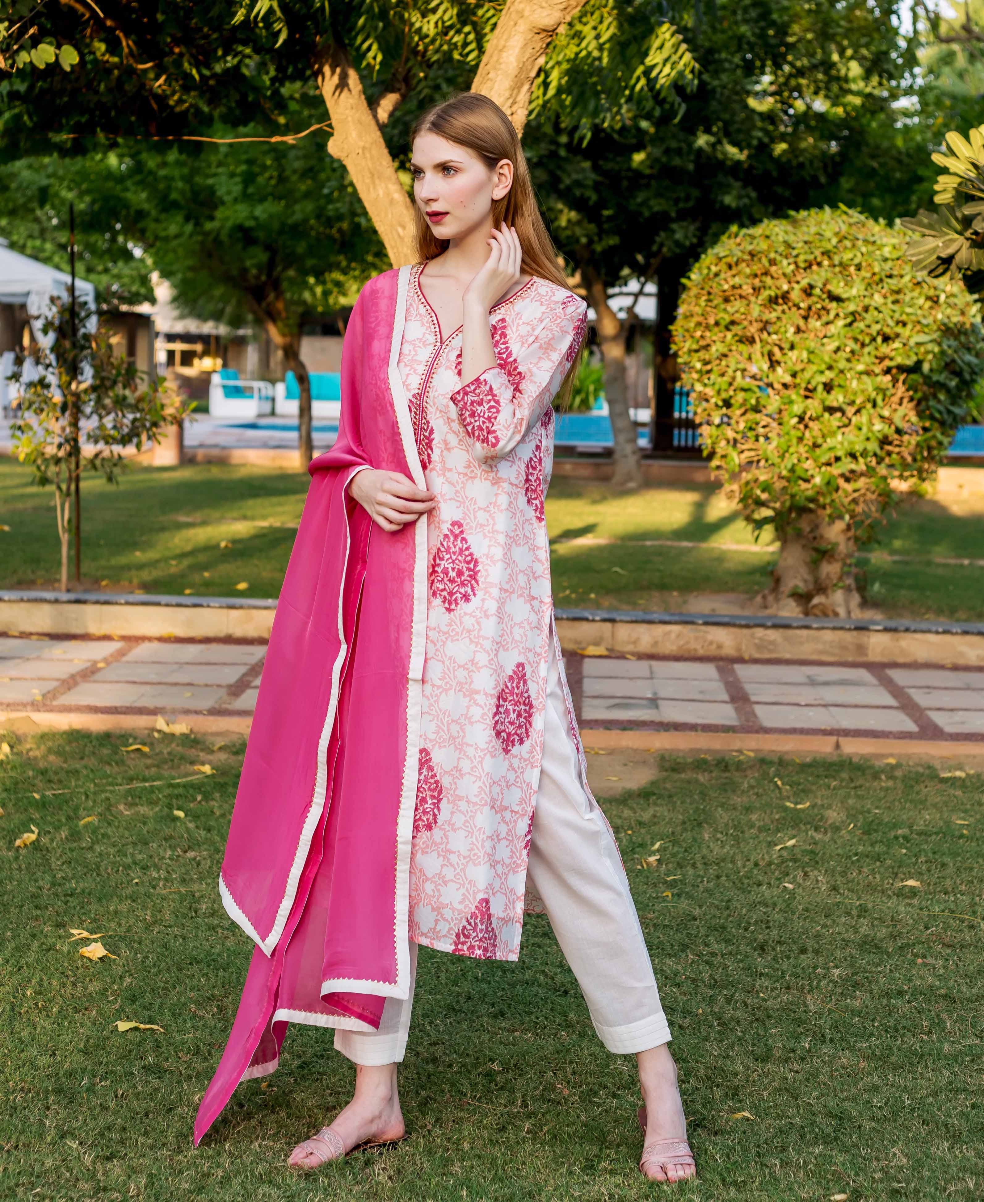 Full length model in a white kurta with peach-pink block print and vibrant pink dupatta.