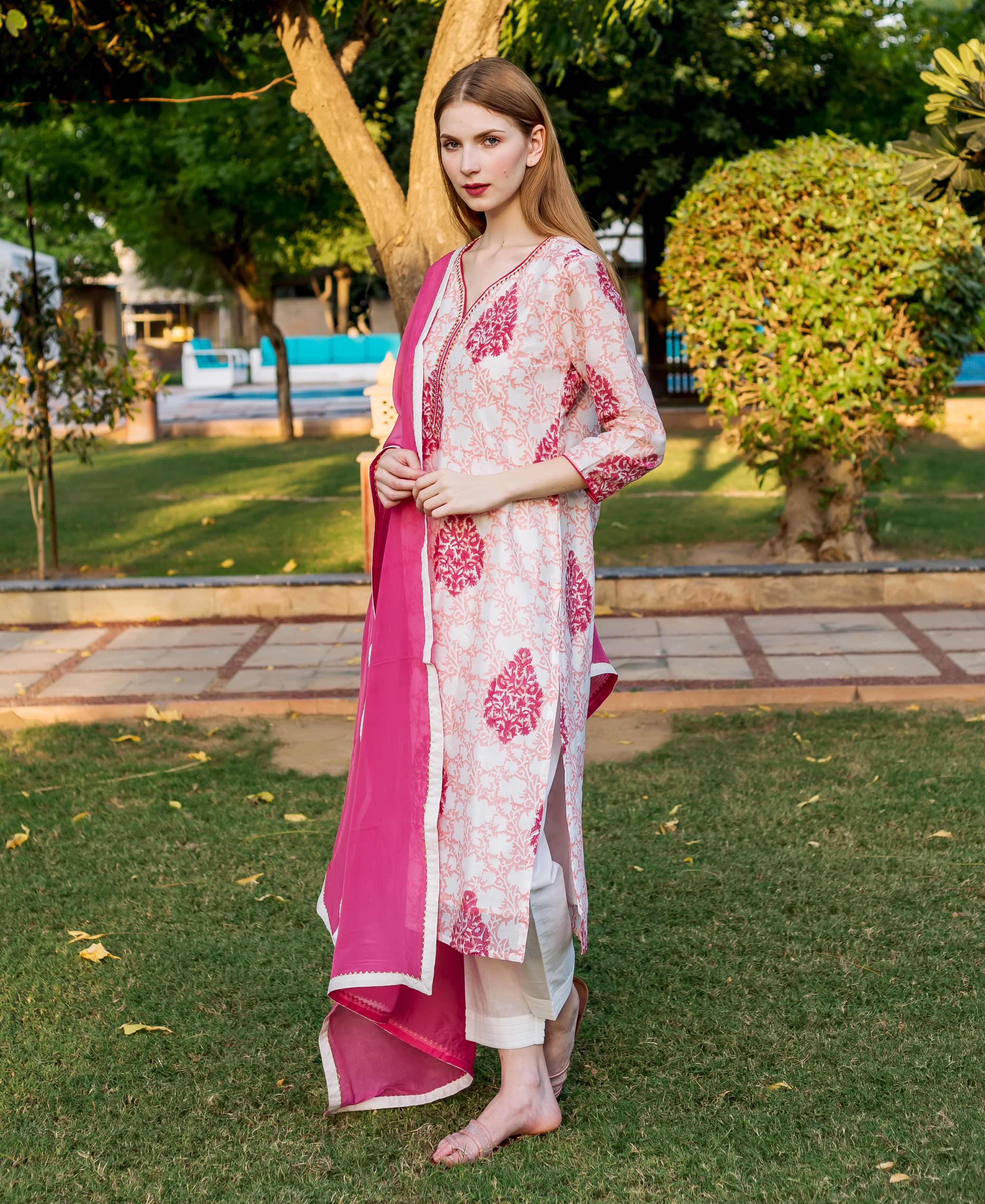 A model wearing a peach and pink block-printed kurta with a floral pattern.