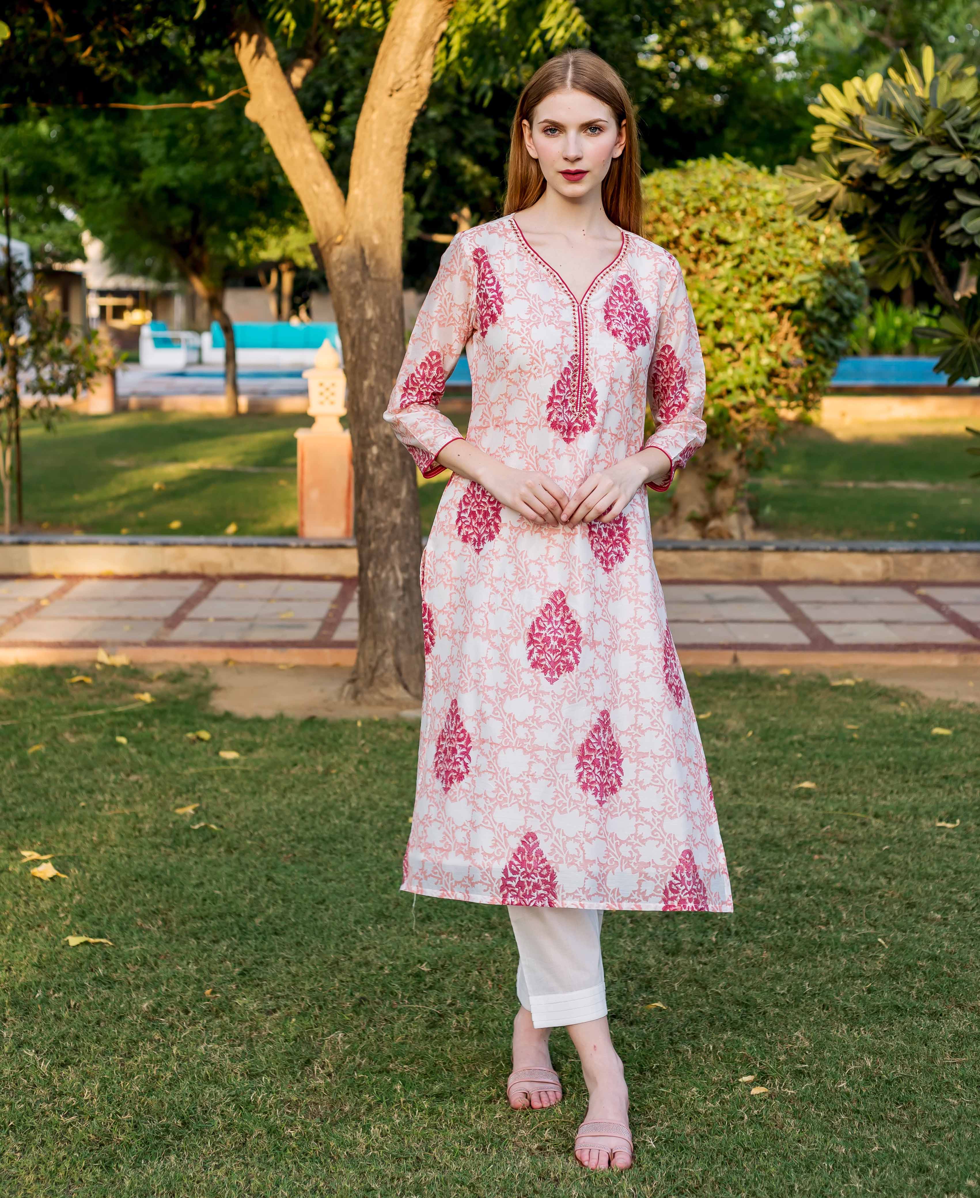 A model wearing a peach and pink block-printed kurta with a floral pattern.