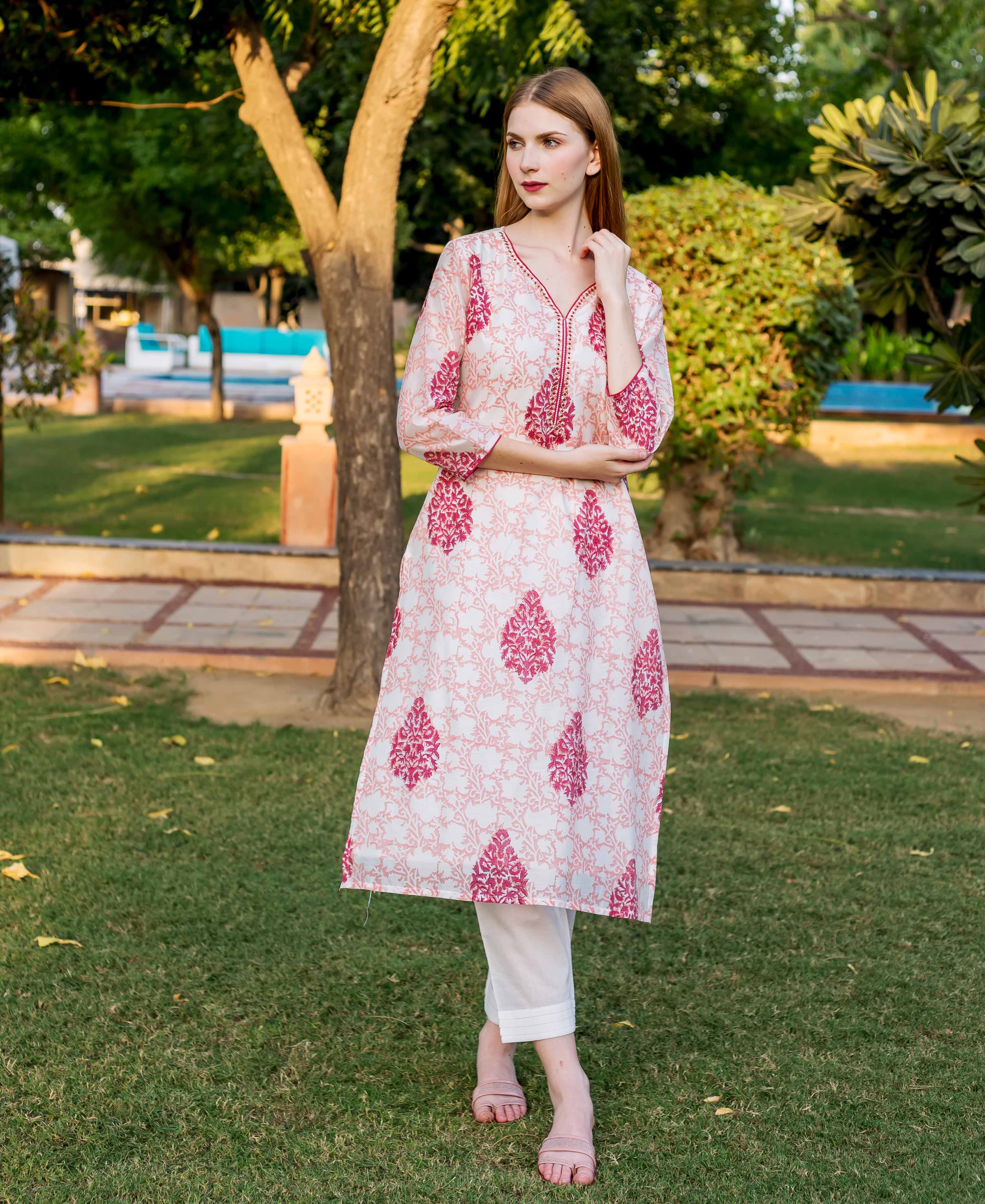 A model wearing a peach and pink block-printed kurta with a floral pattern.