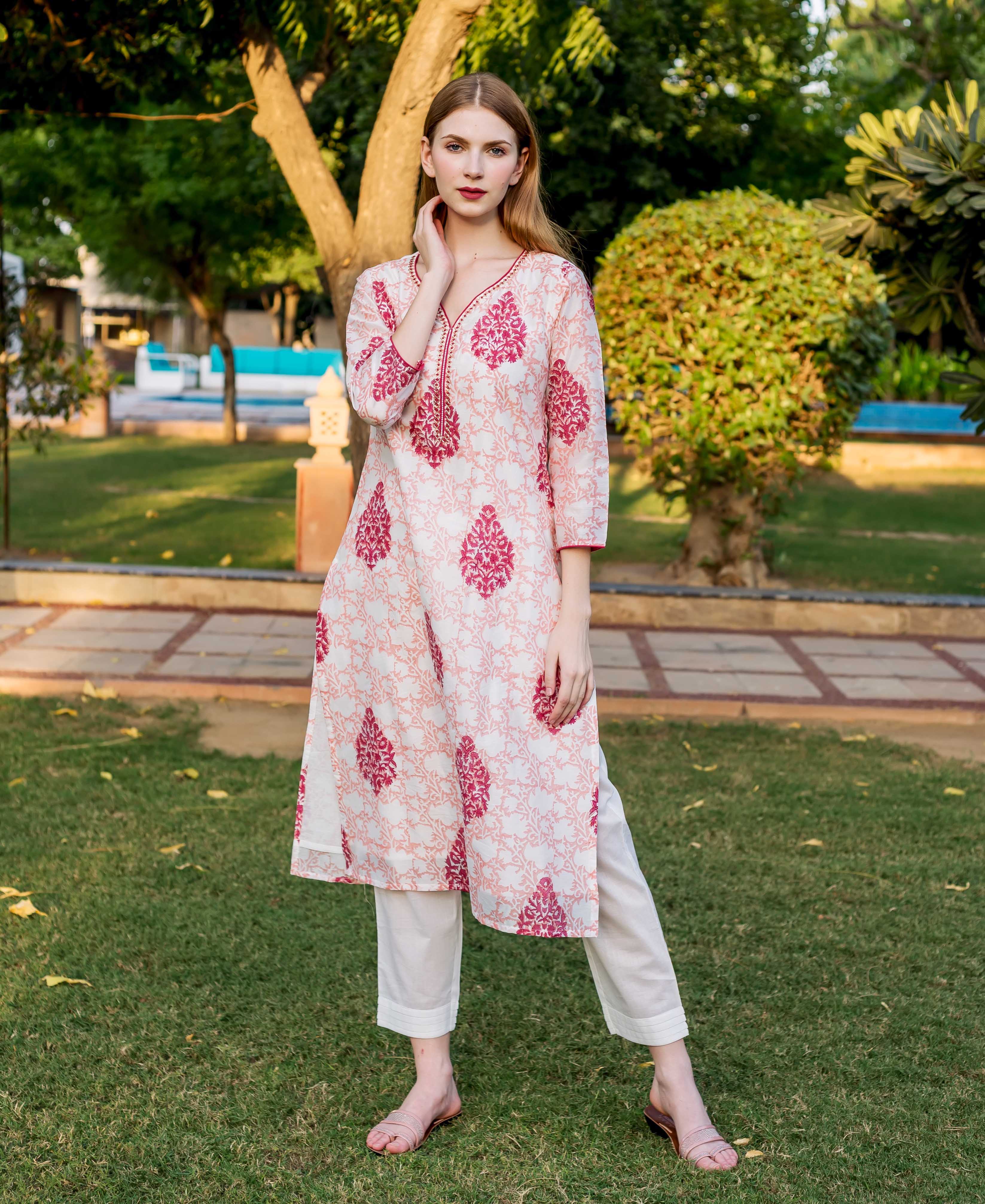 Model wears a peach and pink block printed ethnic kurta and white pants.