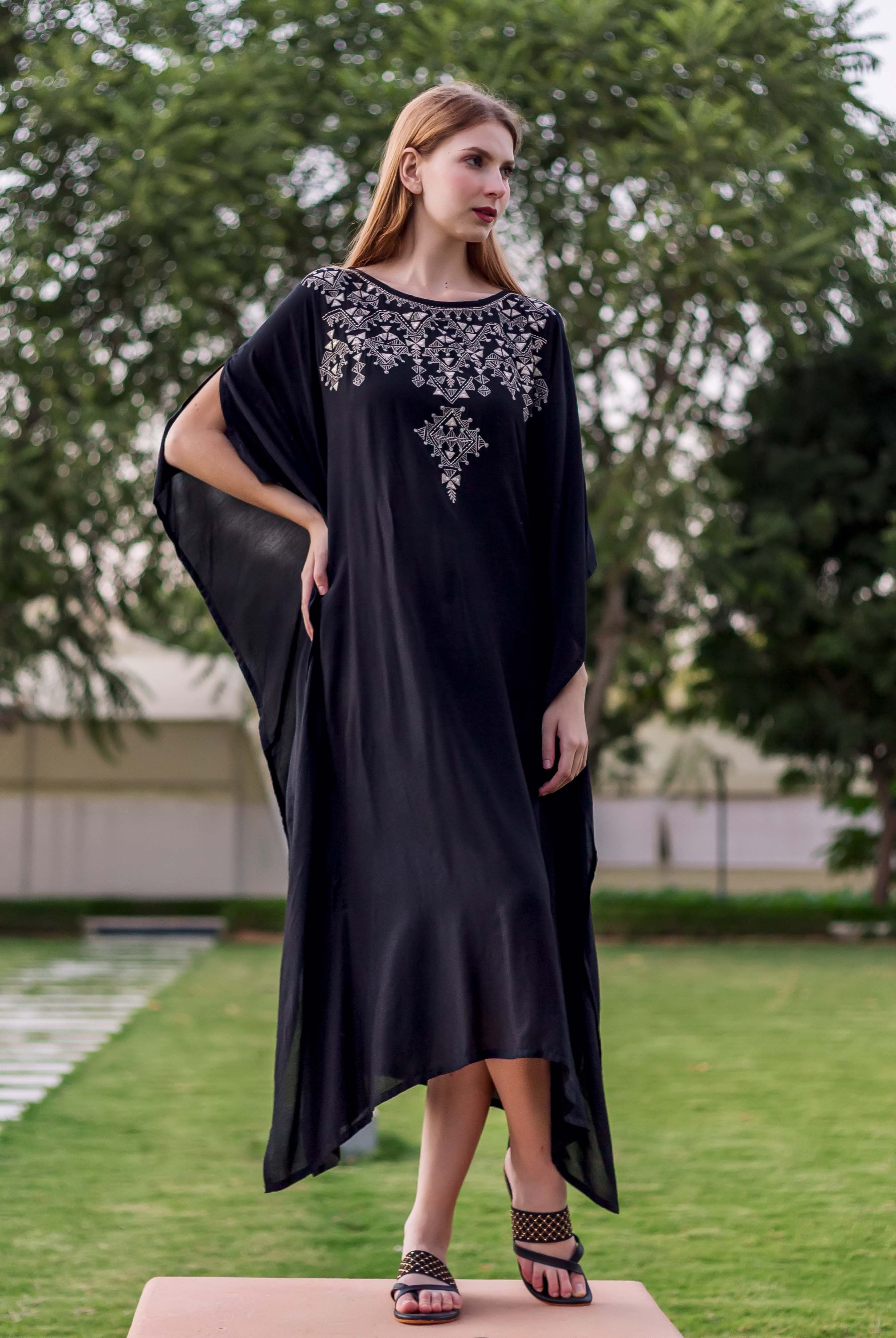 A model wearing a black kaftan with silver embroidery.