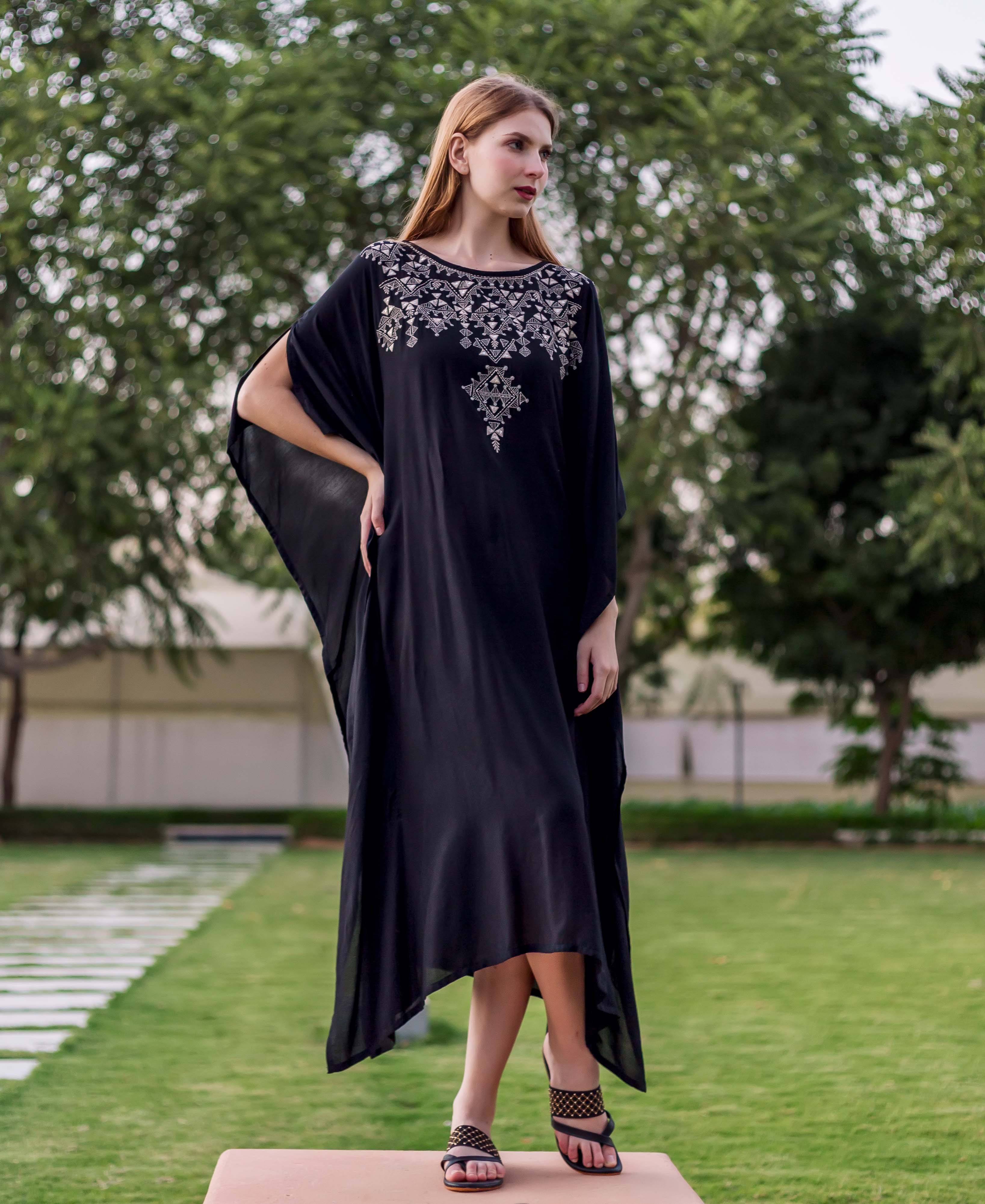 A model wearing a black kaftan with silver embroidery.