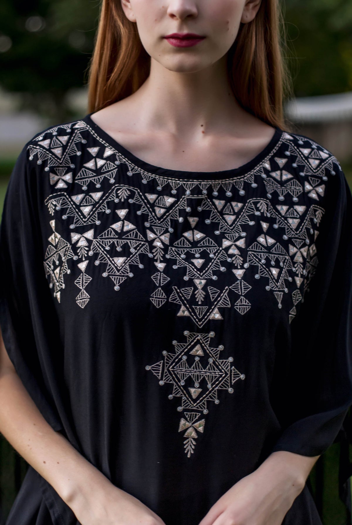 Black kaftan with white embroidery on a model.