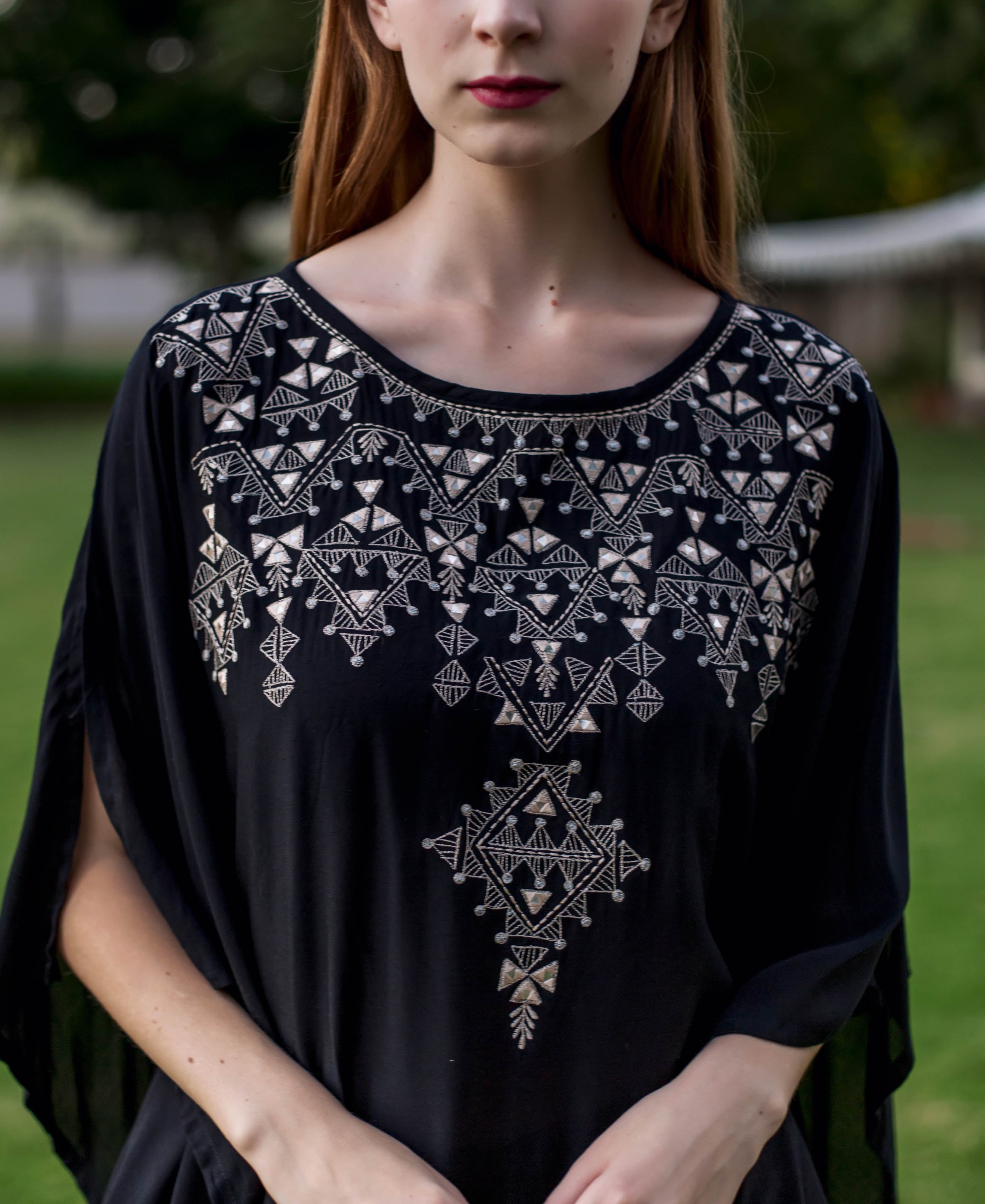 Black kaftan with white embroidery on a model.