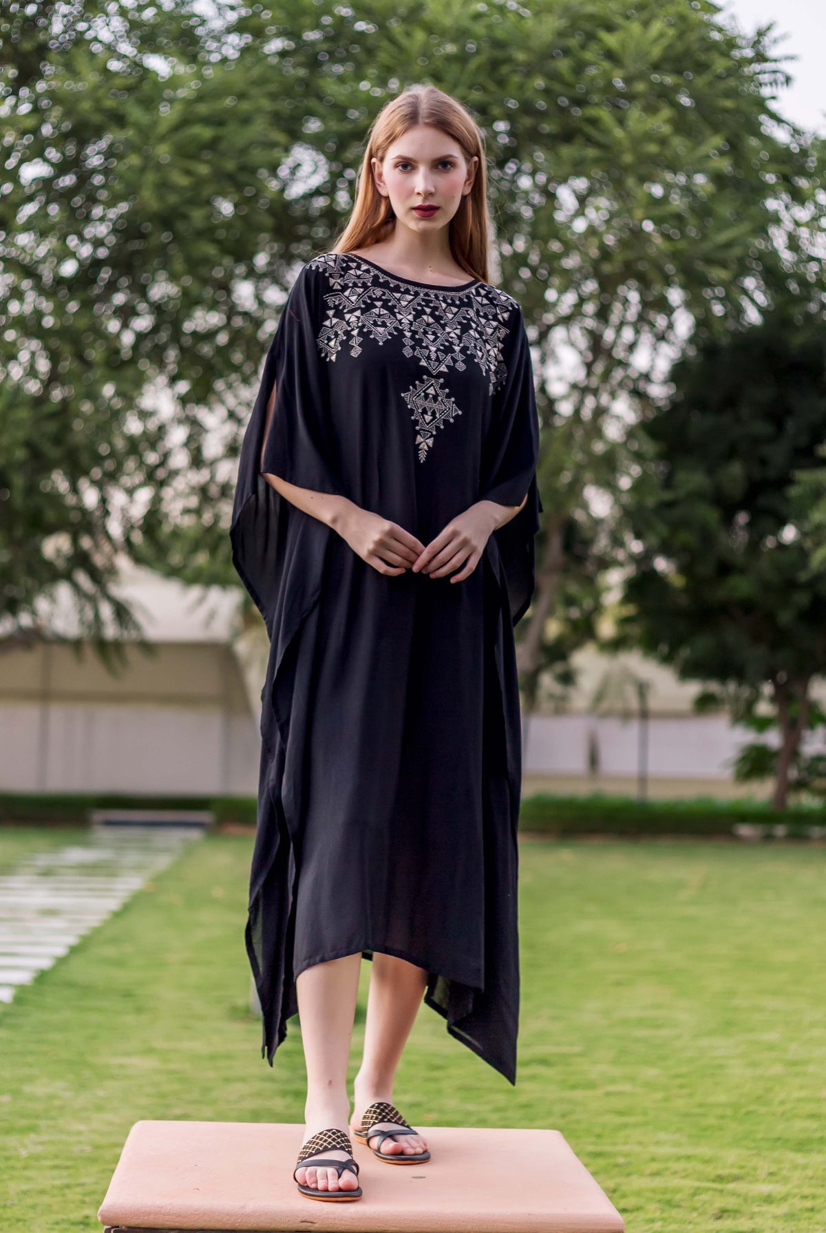 Black muslin embroidered kaftan on model, front view, with silver geometric chest embroidery.