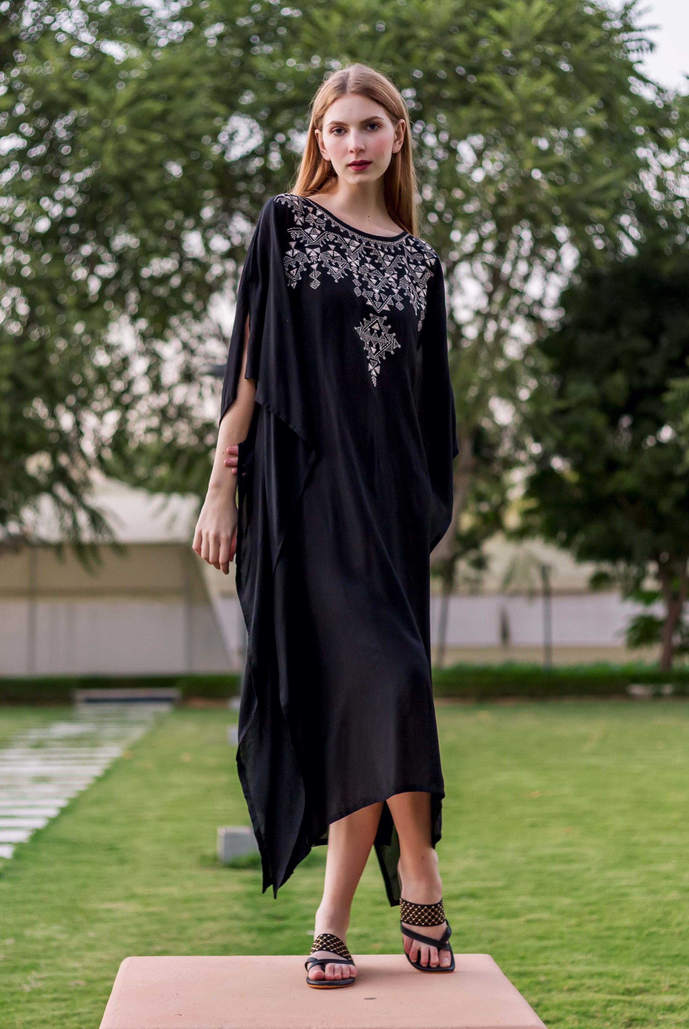 Front view of model in black kaftan with intricate silver embroidered geometric pattern on yoke.
