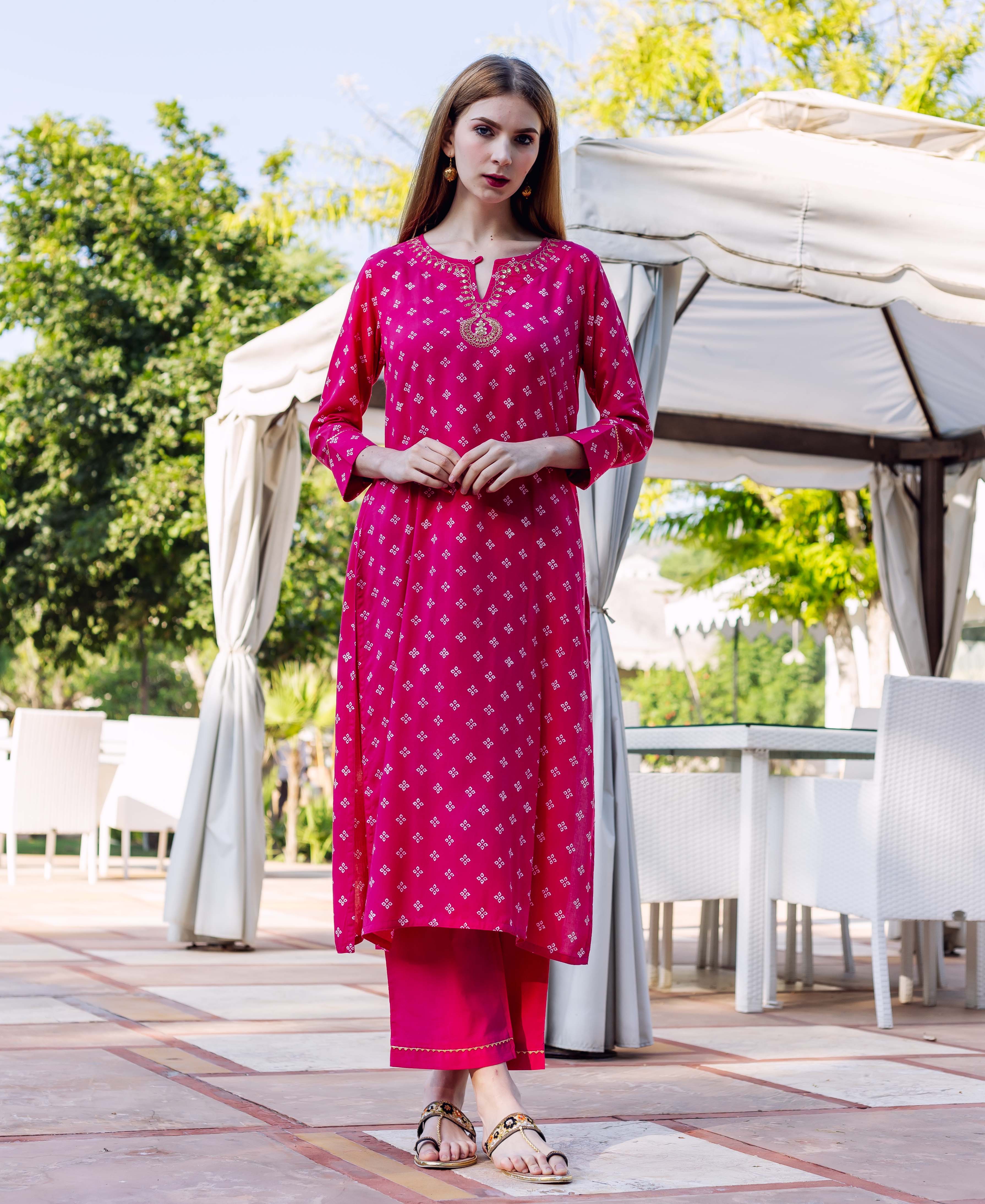 Full view of model in magenta Bandhej printed kurta set with gold embroidered neckline.