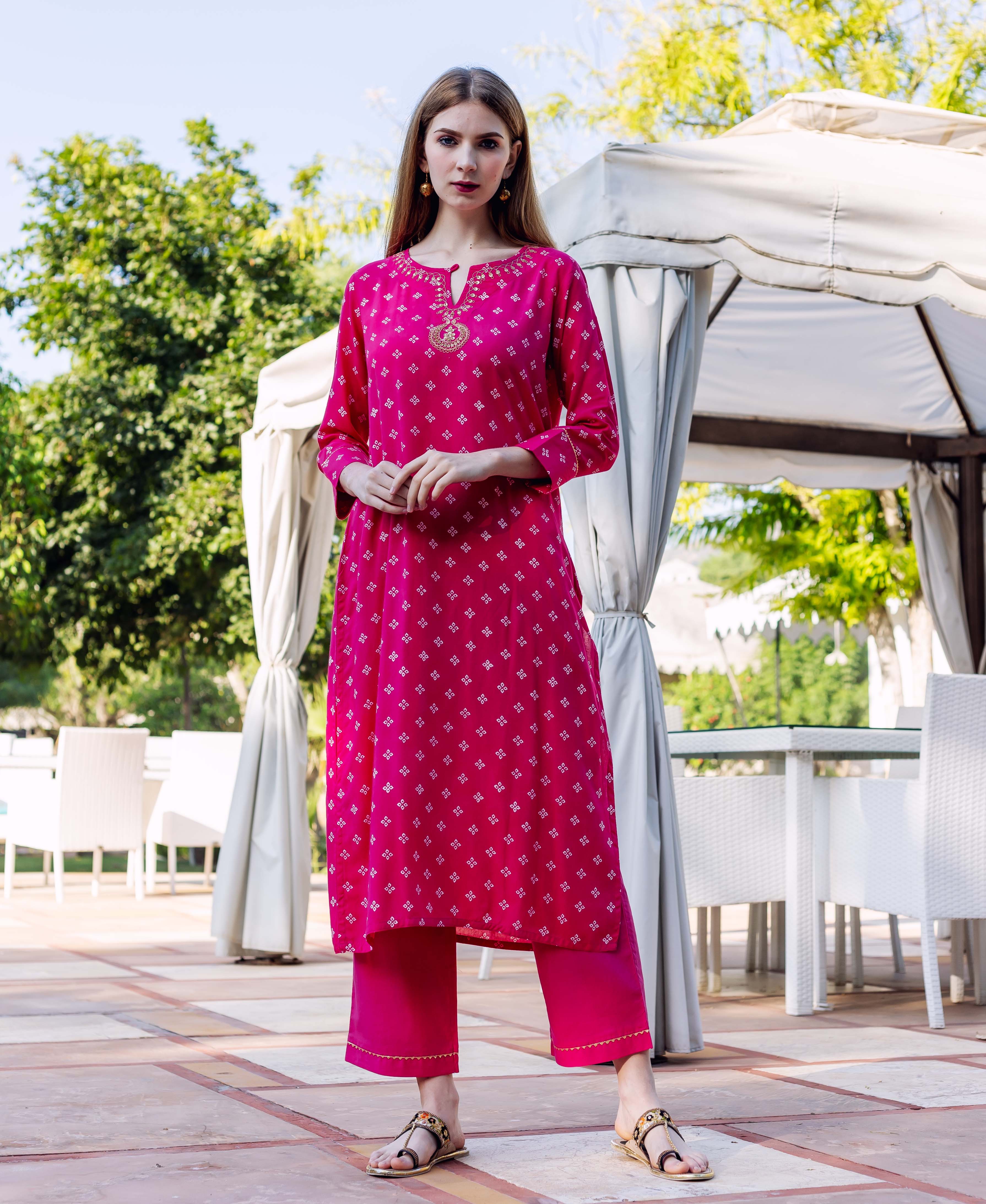 Full shot of a model wearing a magenta Bandhej printed kurta with embroidered neckline and matching pants.