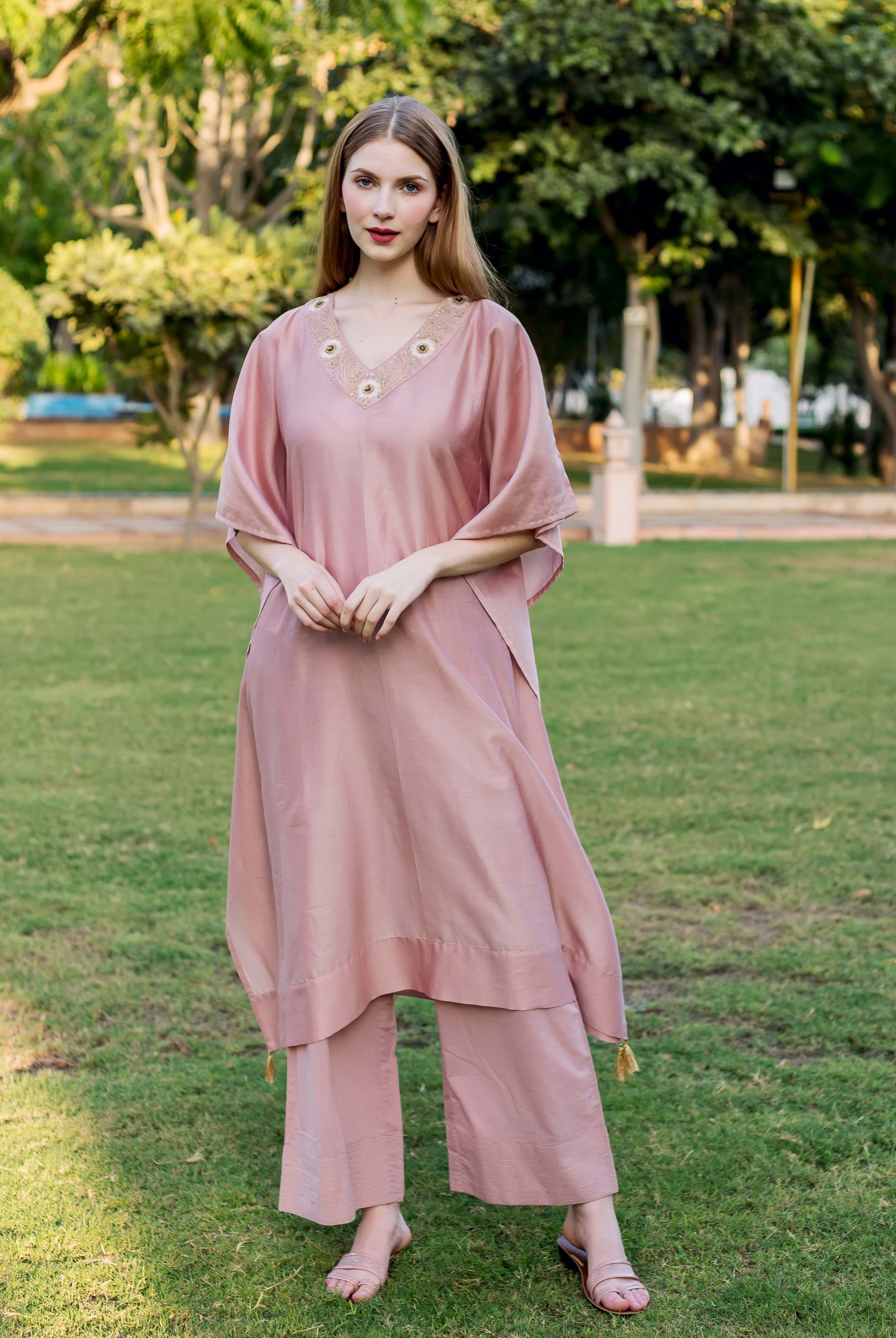 Front view of model in dusty pink hand-embroidered V-neck kaftan and matching pants.