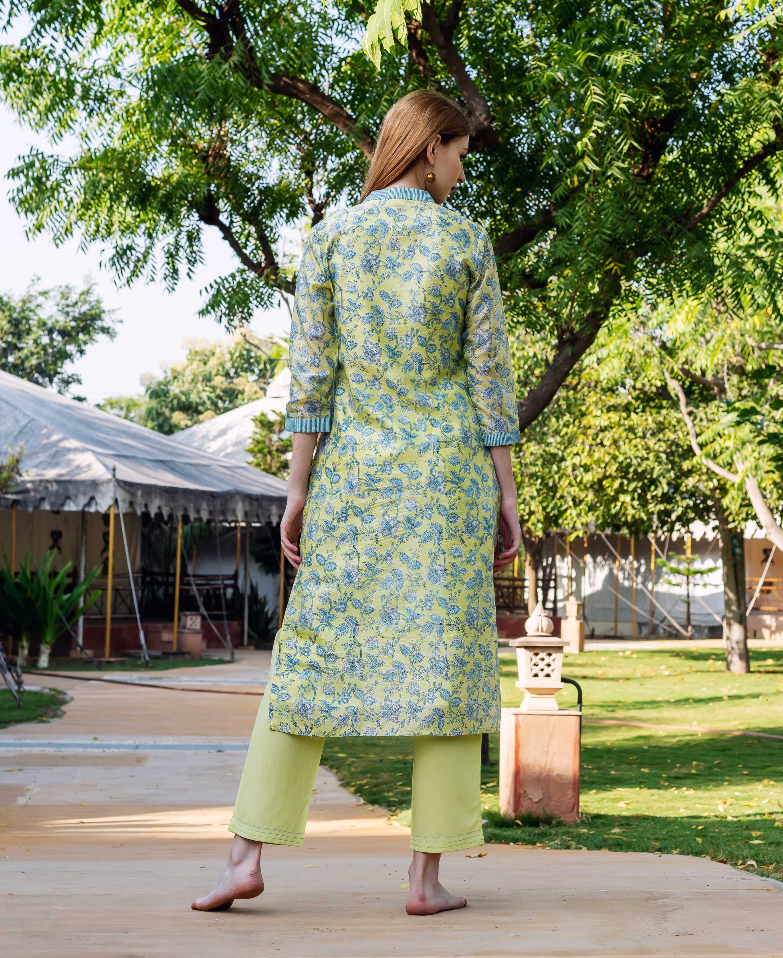 Back view of model wearing lime green hand-block-printed floral kurta with matching pants.