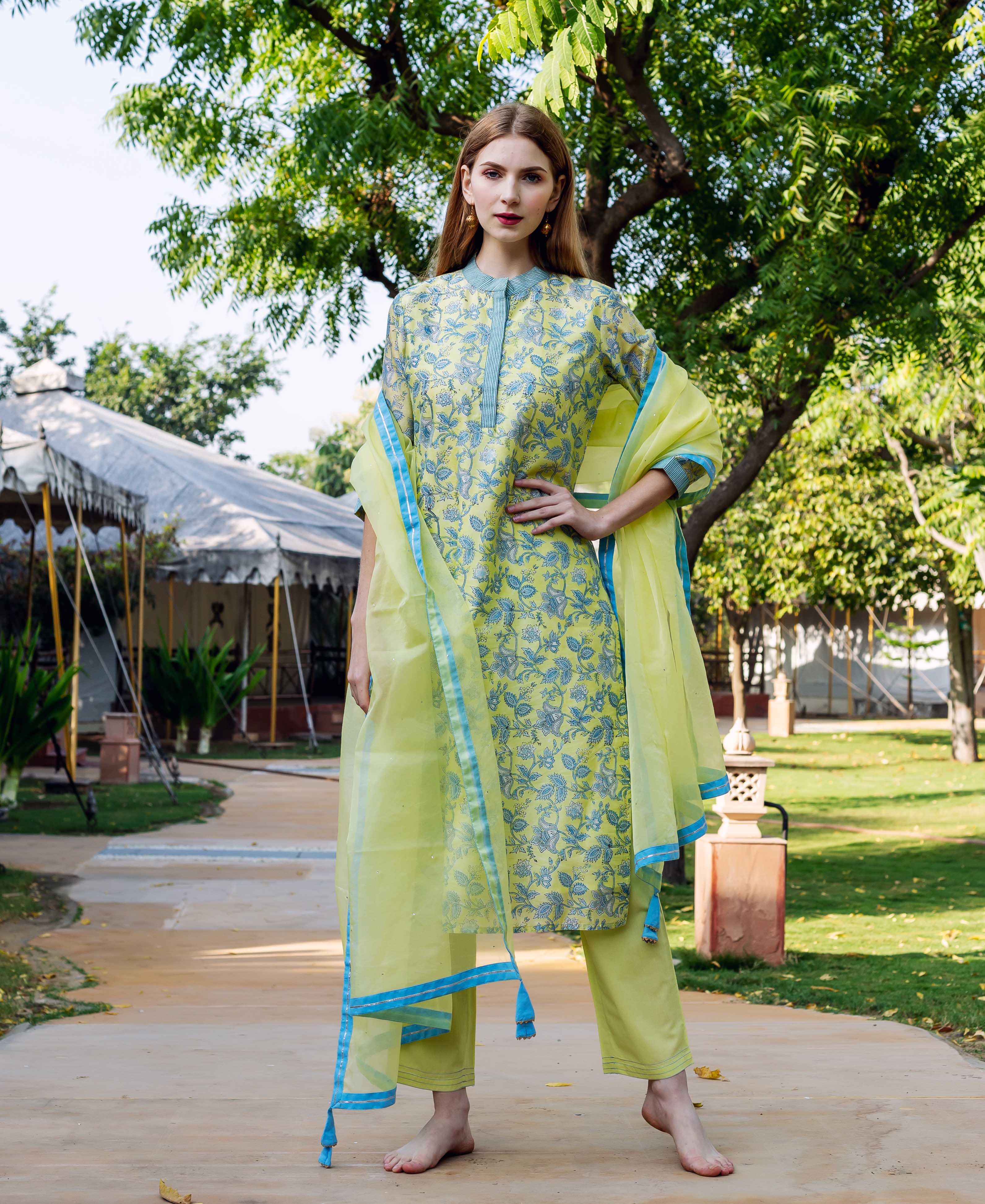 Full-length model in lime green hand-block-printed kurta set with blue floral pattern and dupatta.