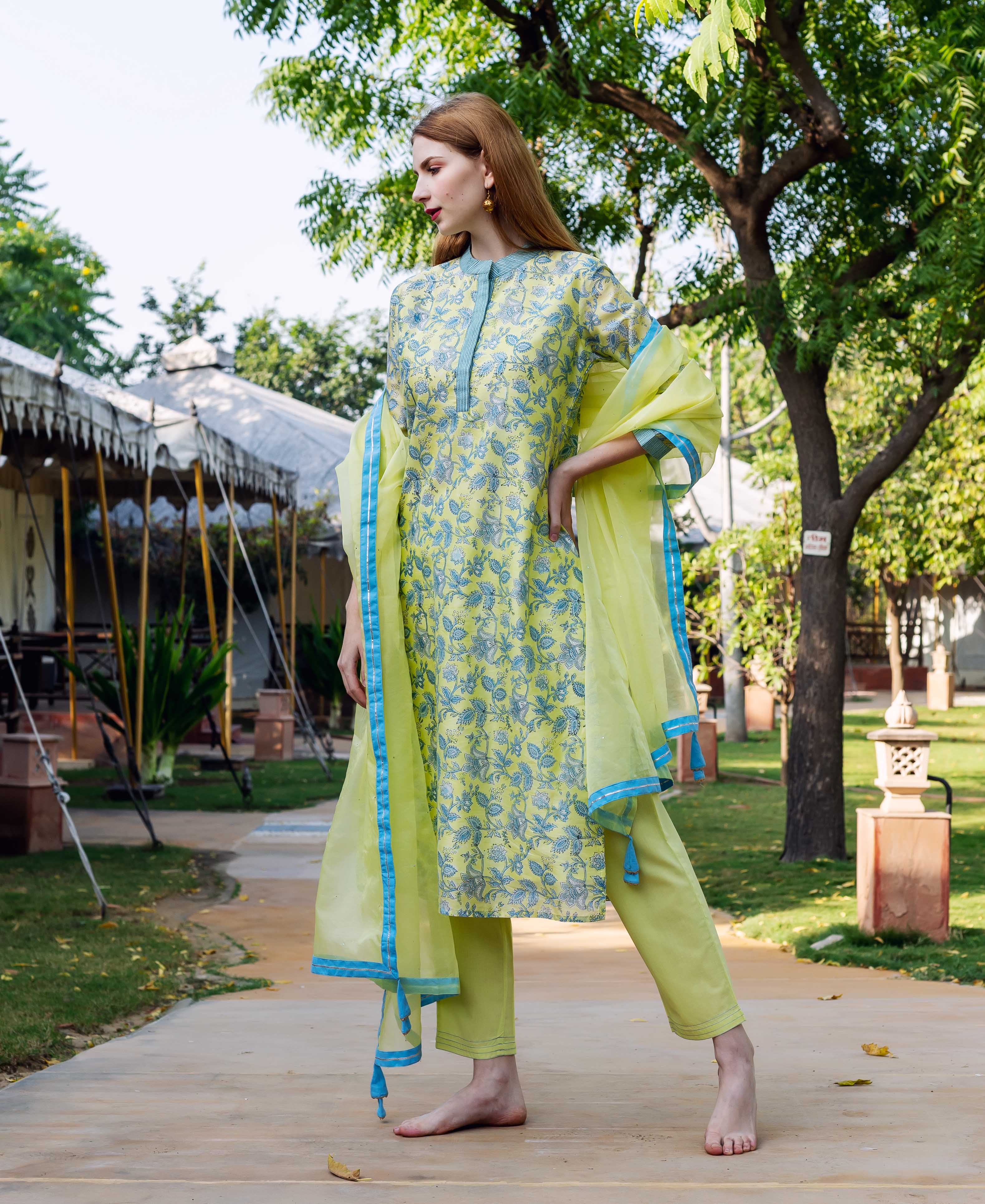 Model wearing light green hand-block-printed chanderi kurta set with blue floral motifs and dupatta.