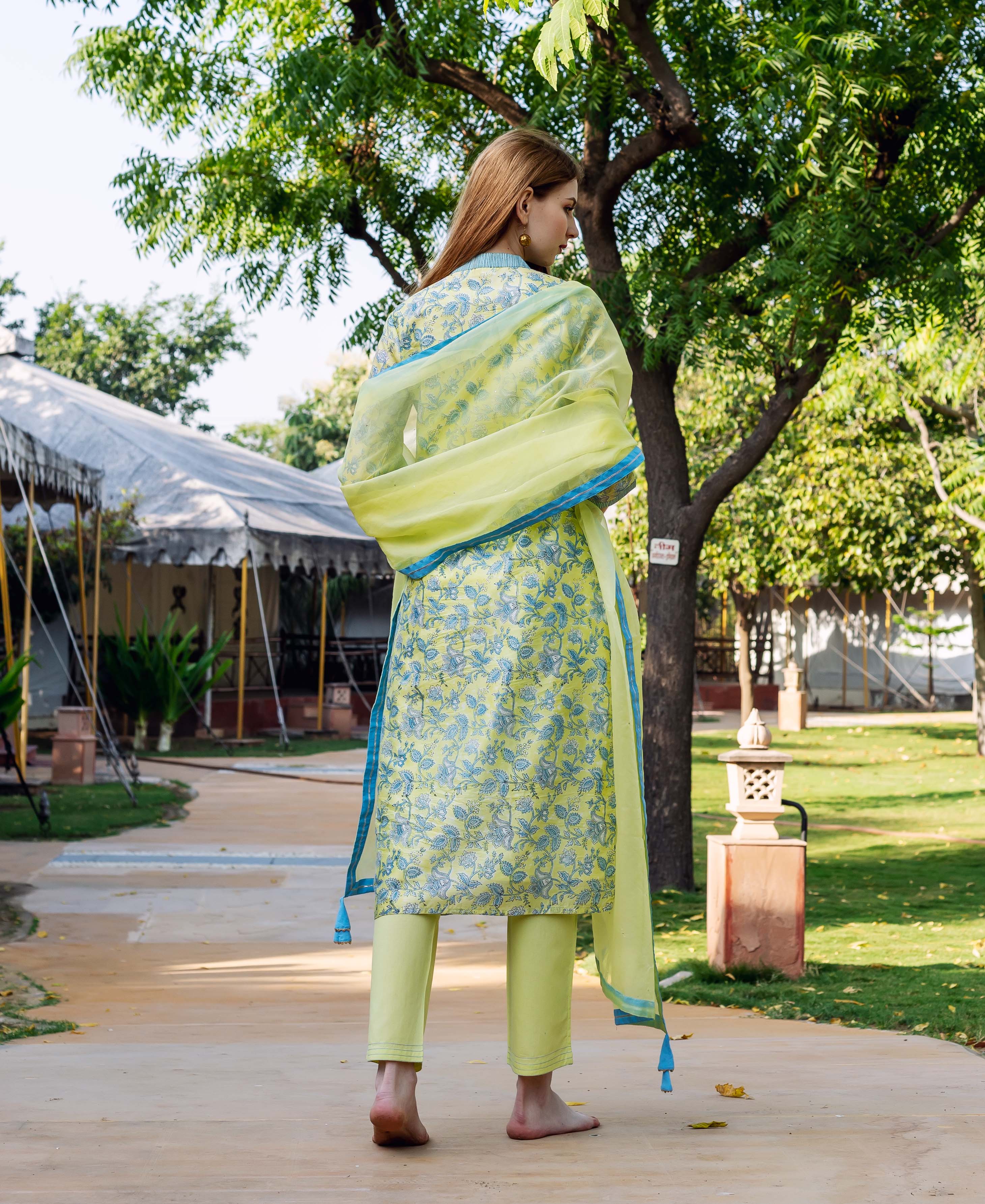 Model from behind wearing light green chanderi kurta set with blue floral block print.