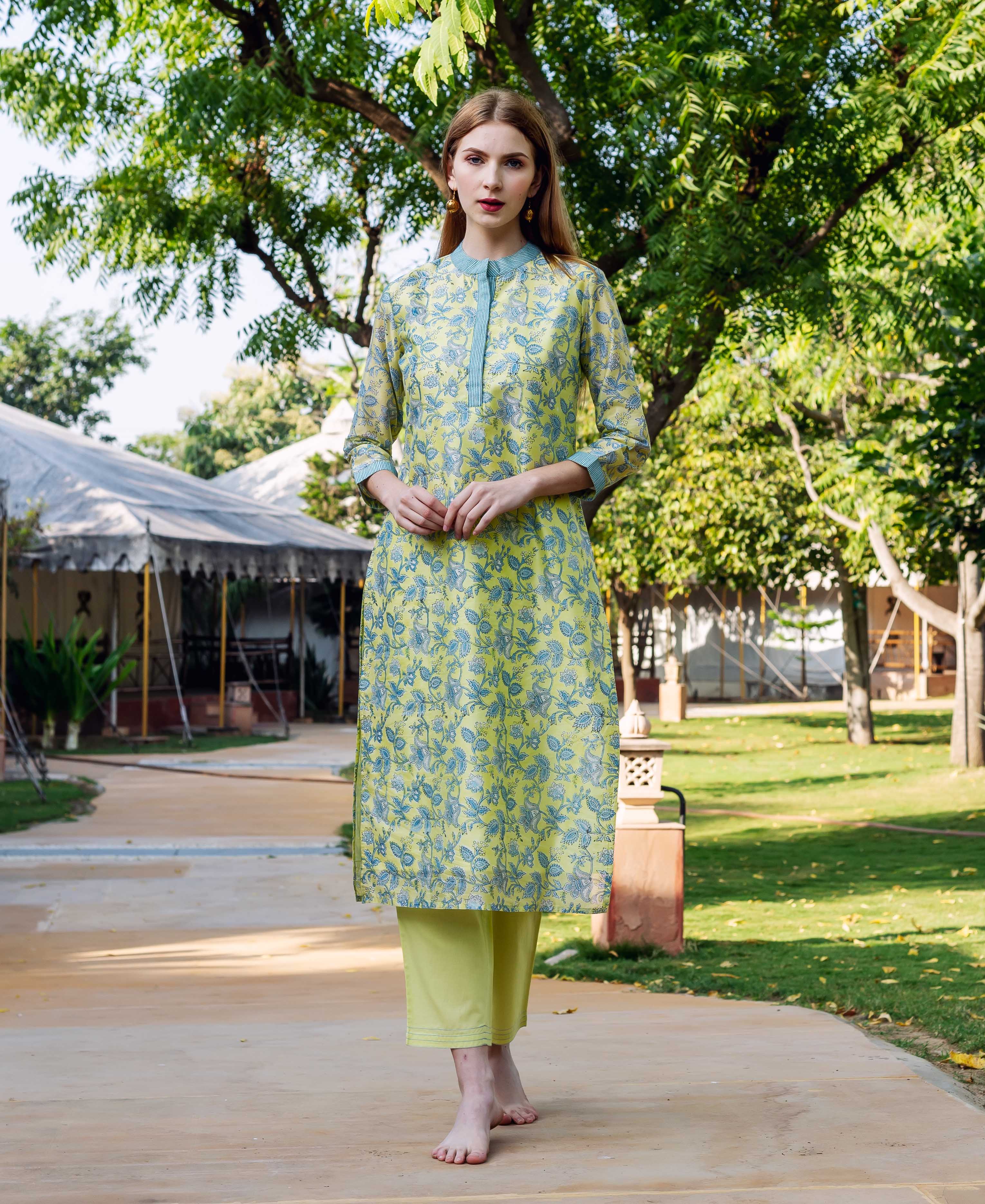 Front view of a model wearing a light green kurta with blue floral block print and matching pants.