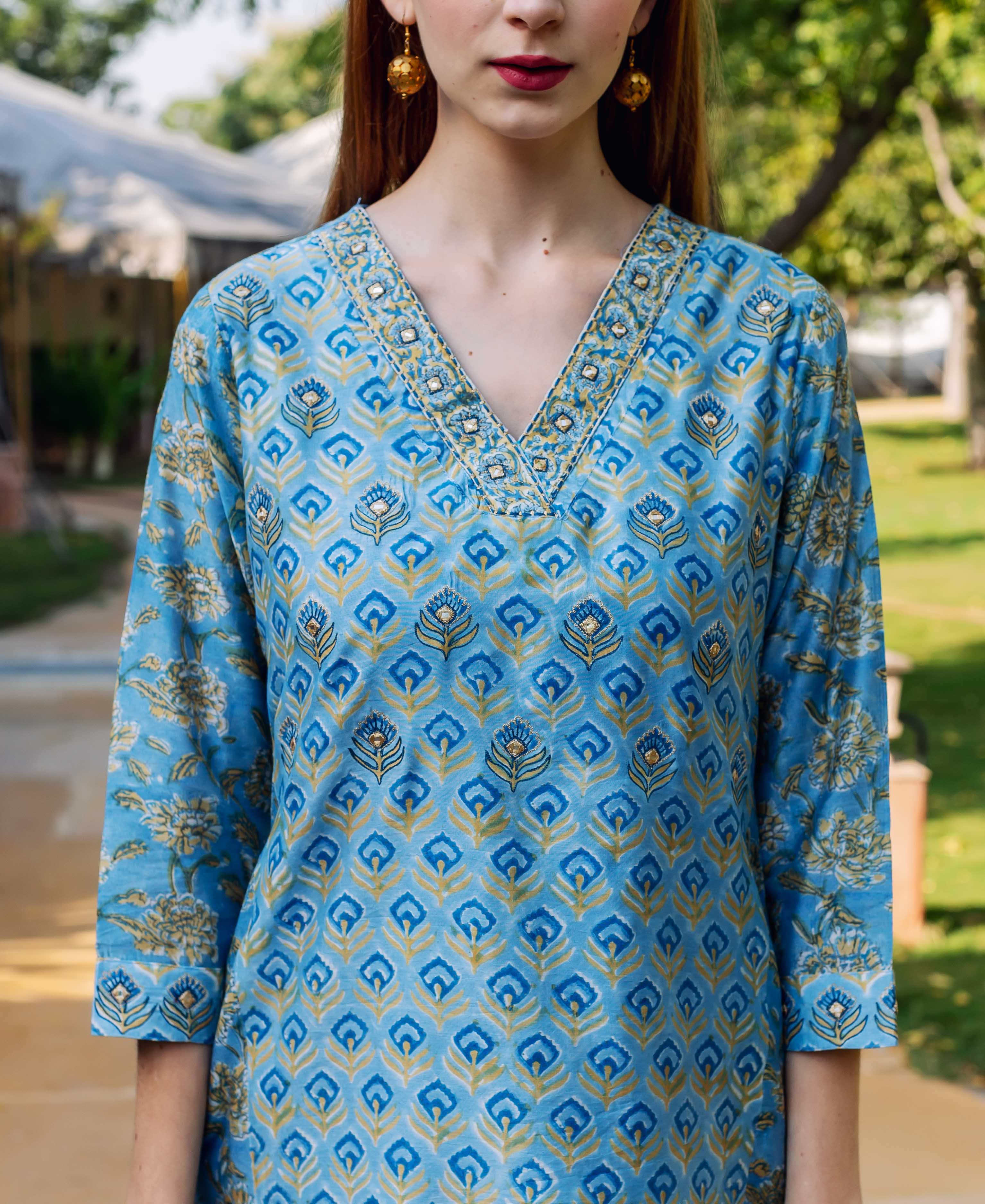 Front view of model wearing a blue hand-block-printed kurta with golden ethnic patterns, embellished V-neck.
