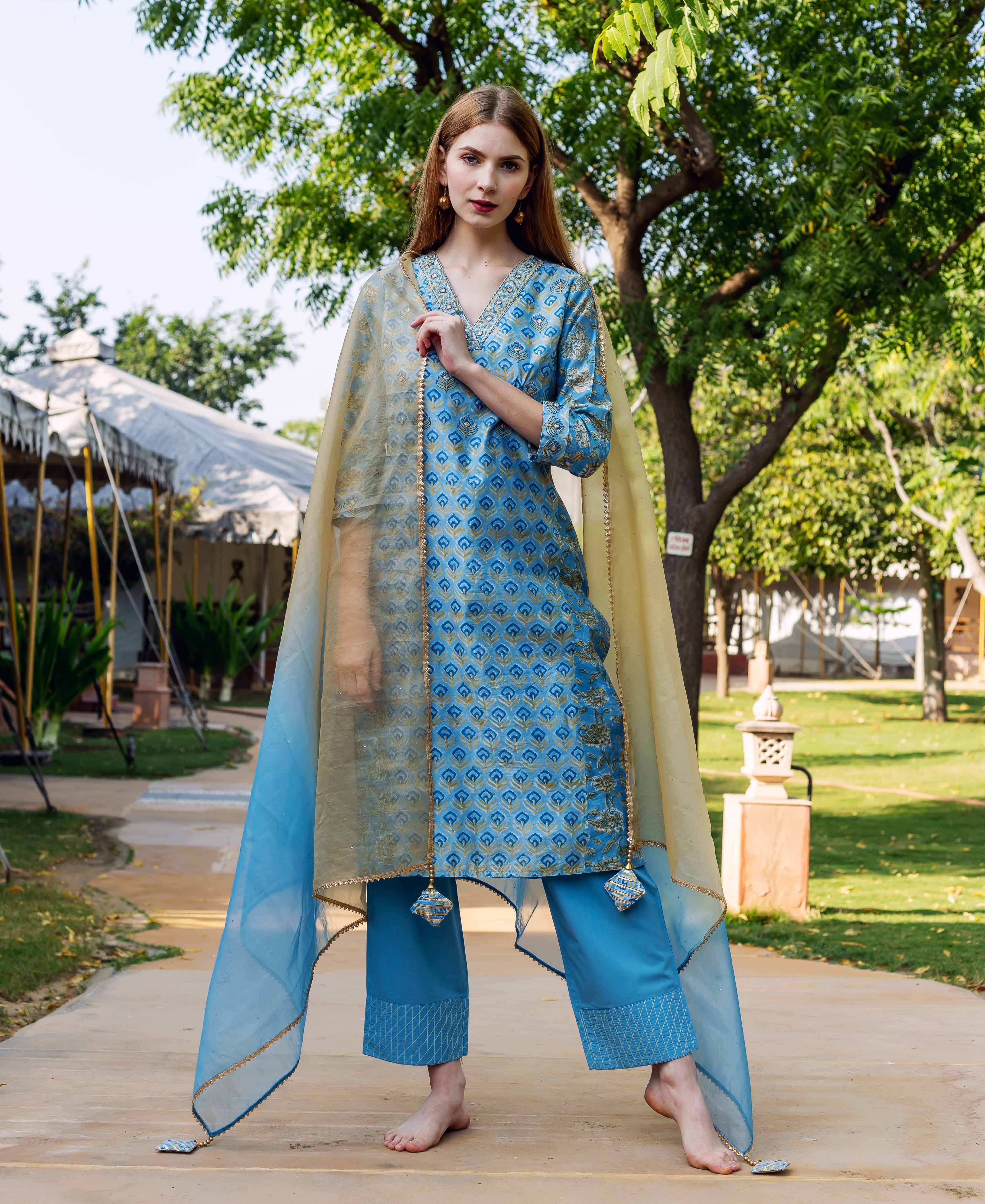 Model poses full-front wearing a blue hand-block-printed kurta set with matching pants and ombre dupatta.
