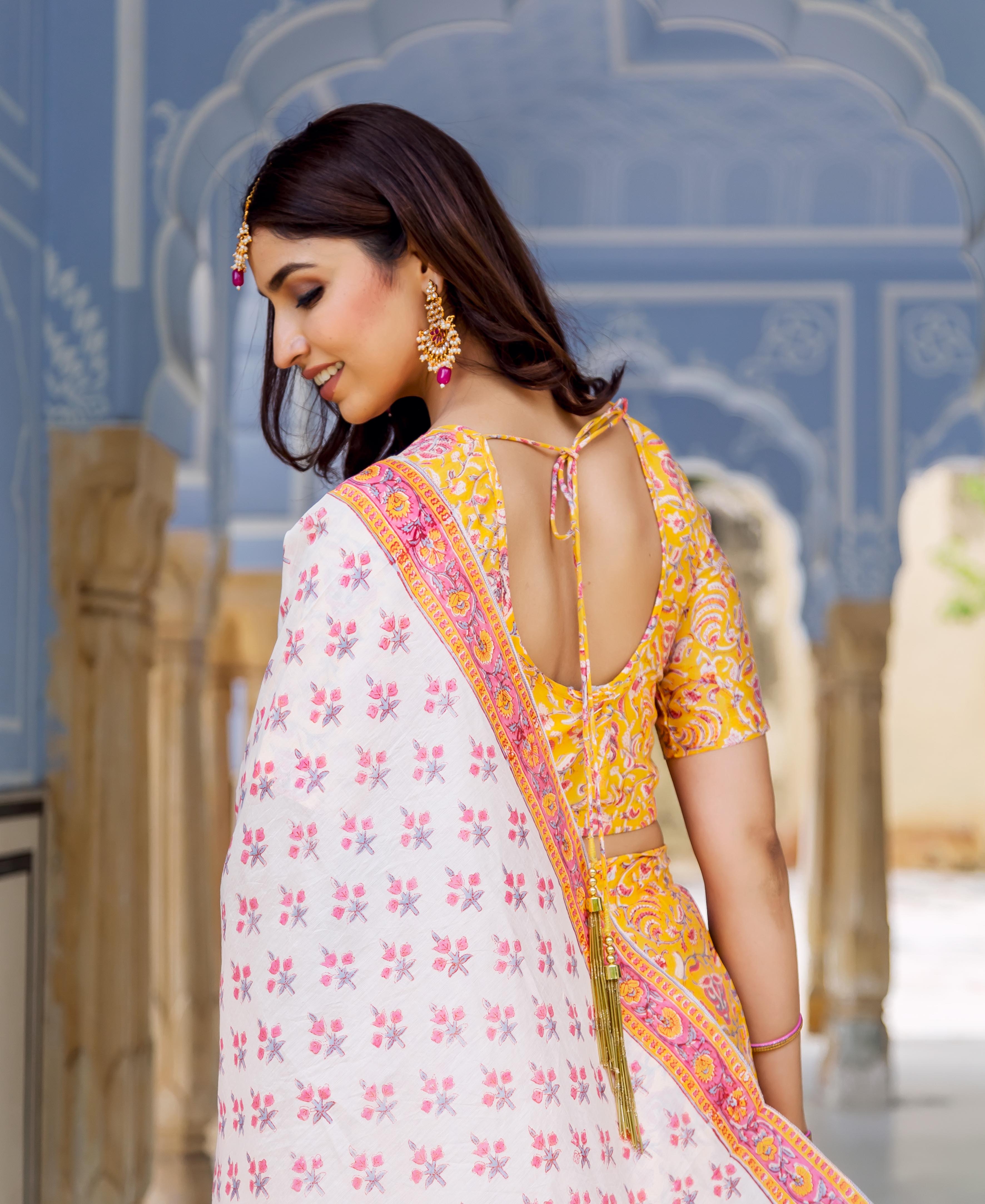 Side-back view of model in yellow and white hand block printed lehenga set.