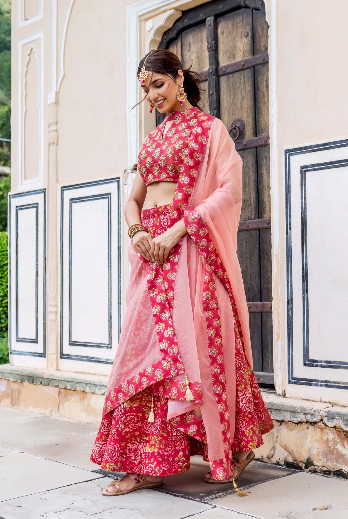 Model in vibrant pink hand-block printed and embroidered floral lehenga set.